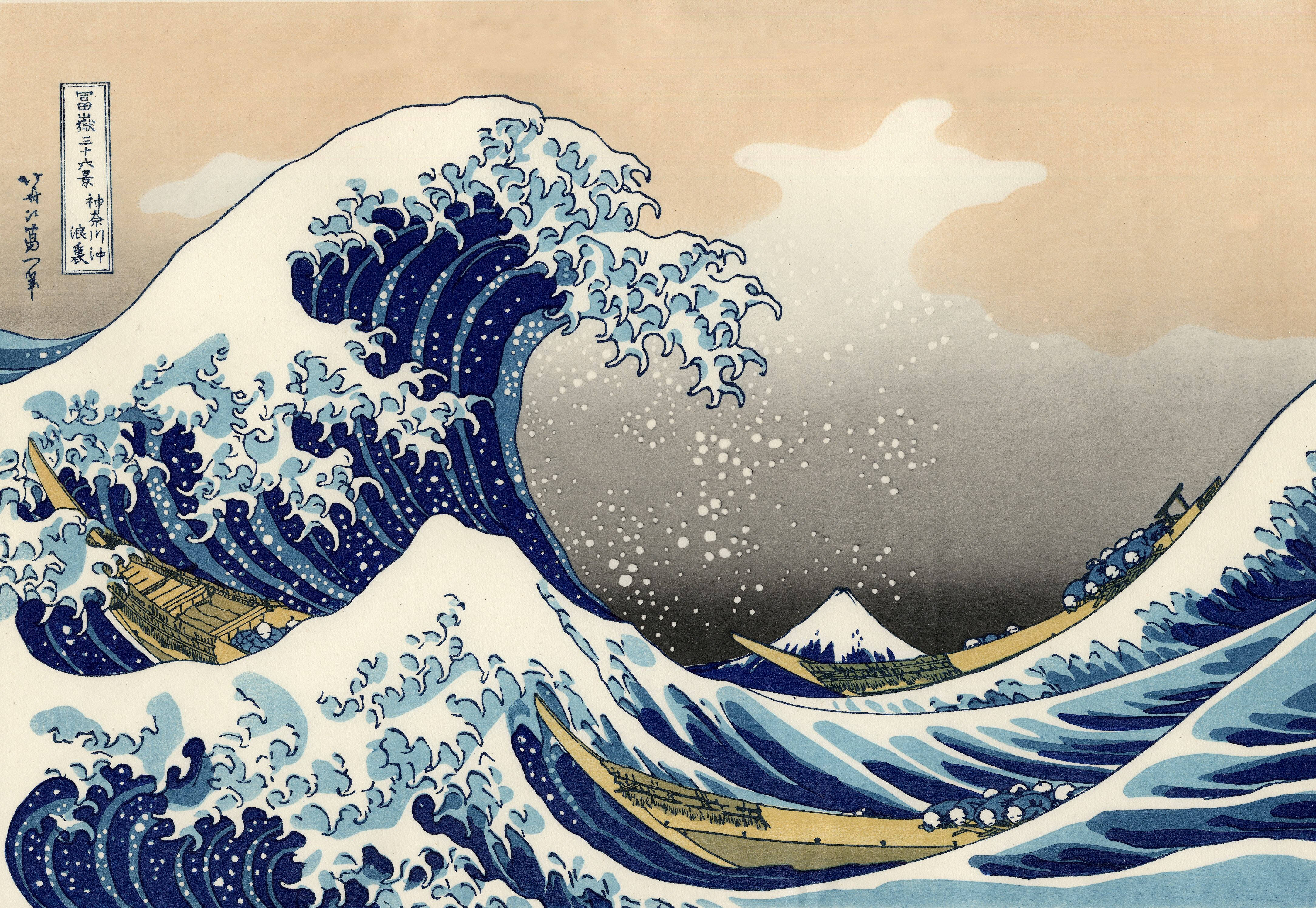 日式海浪 桌布 壁紙 — 一道高聳的藍色巨浪衝擊船隻，遠處富士山在蒼白的天空下清晰可見。