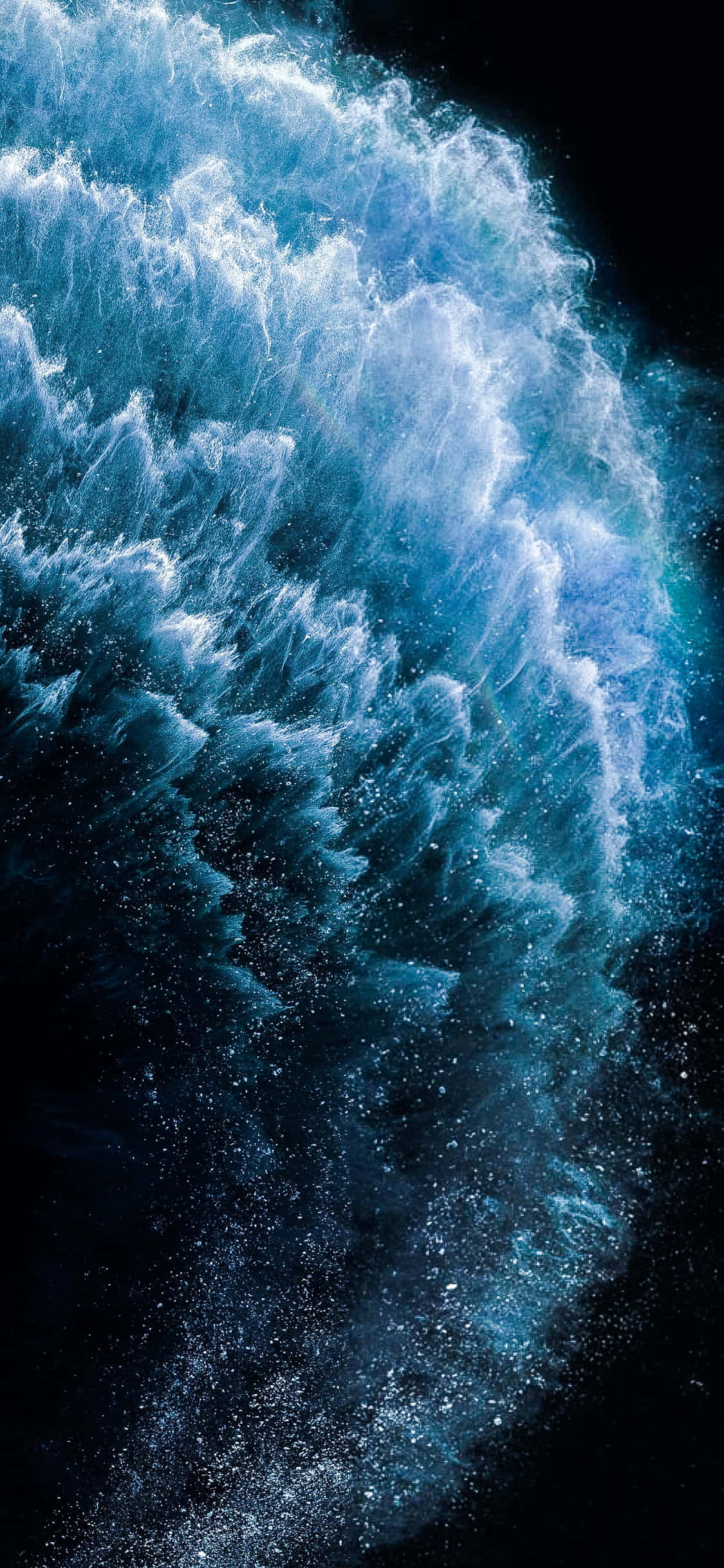 4K 桌布 壁紙 — 一道高聳的藍色波浪衝破黑暗，帶著泡沫般的白色飛沫和閃閃發光的水滴，定格在運動中。
