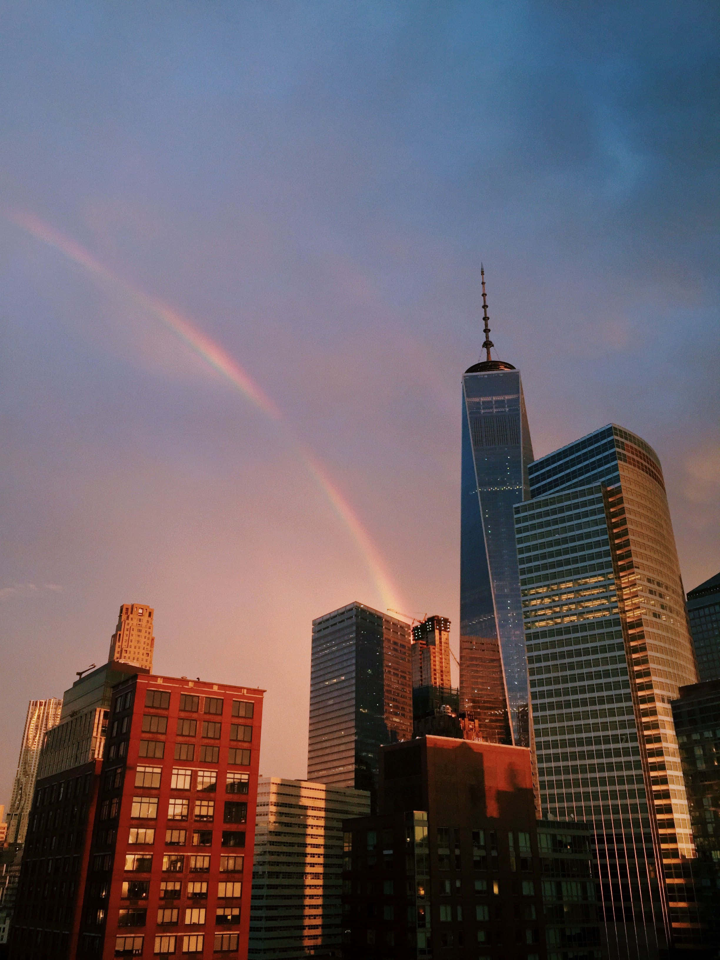 Nyc Aesthetic 桌布 壁紙 — 一道鮮豔的彩虹在色彩繽紛的日落時分橫跨 One World Trade Center 及周邊摩天大樓。