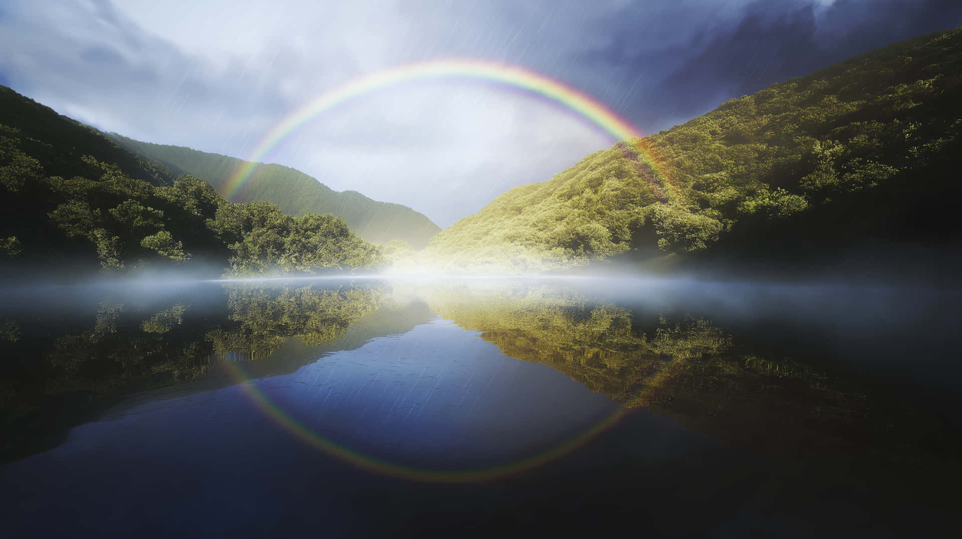 Circular Rainbow Over Misty Mountain Valley Lake 壁紙 — 一道鮮豔的彩虹在雲天之下，橫跨於被森林覆蓋的山丘之間、霧氣瀰漫的湖面上。