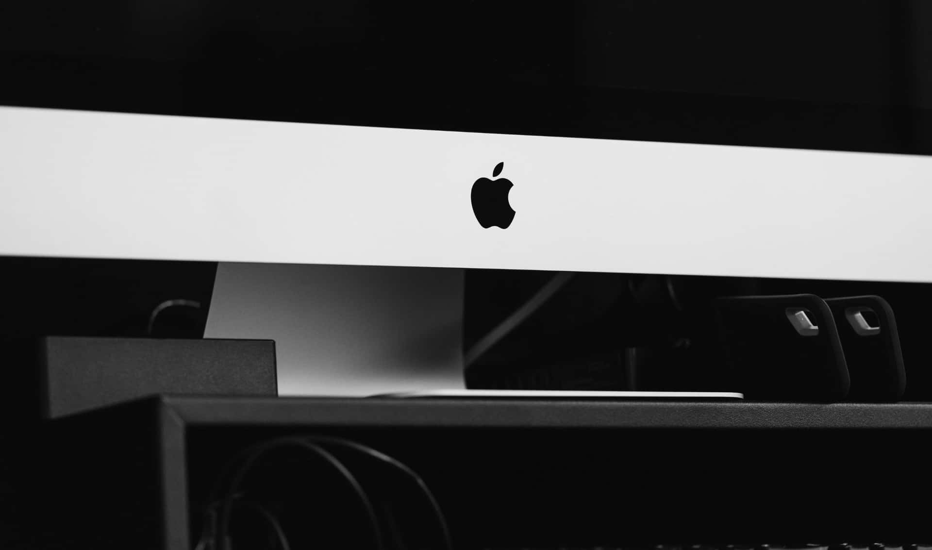 黑白 桌布 壁紙 — 一部 Apple iMac 的極簡黑白特寫，其標誌性標誌位於纖薄的白色邊框中央。