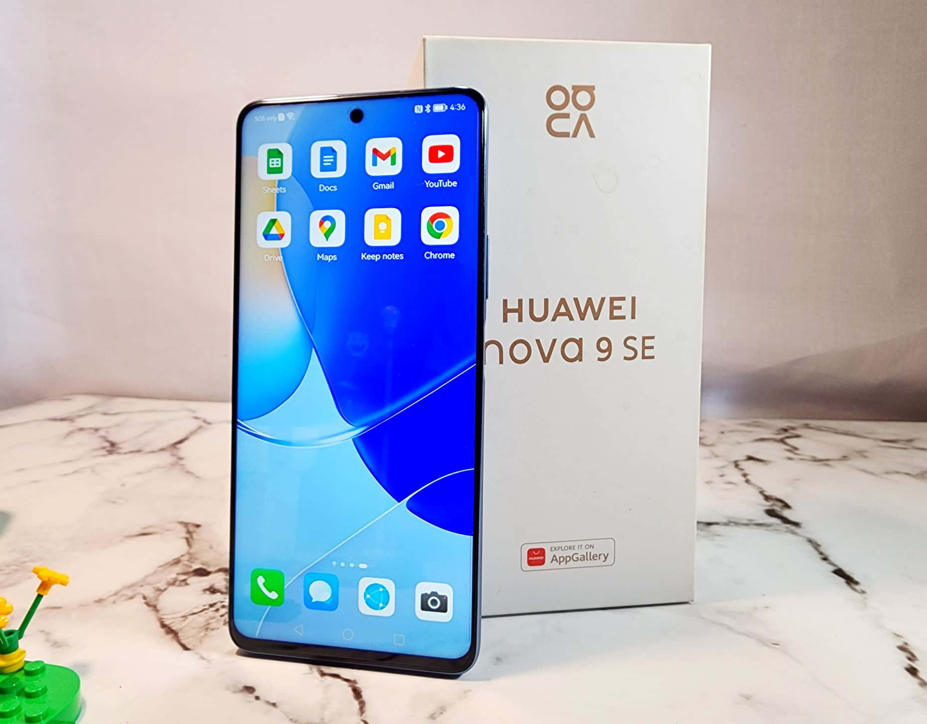 Huawei Nova 9 SE 智慧型手機與其盒子一起展示在大理石檯面上。 — 華為 GIF 壁紙