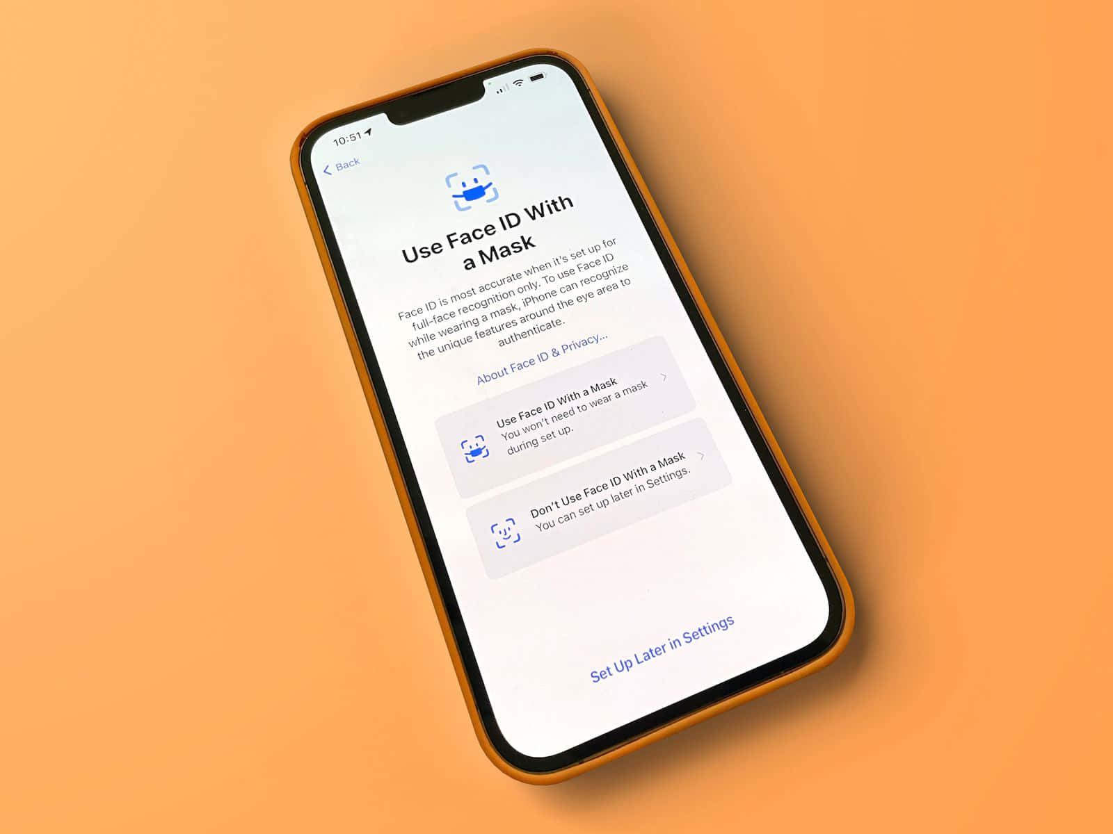 Face Id 桌布 壁紙 — 一部帶有橙色保護殼的智慧型手機在純橙色背景上顯示 Face ID 設定畫面。