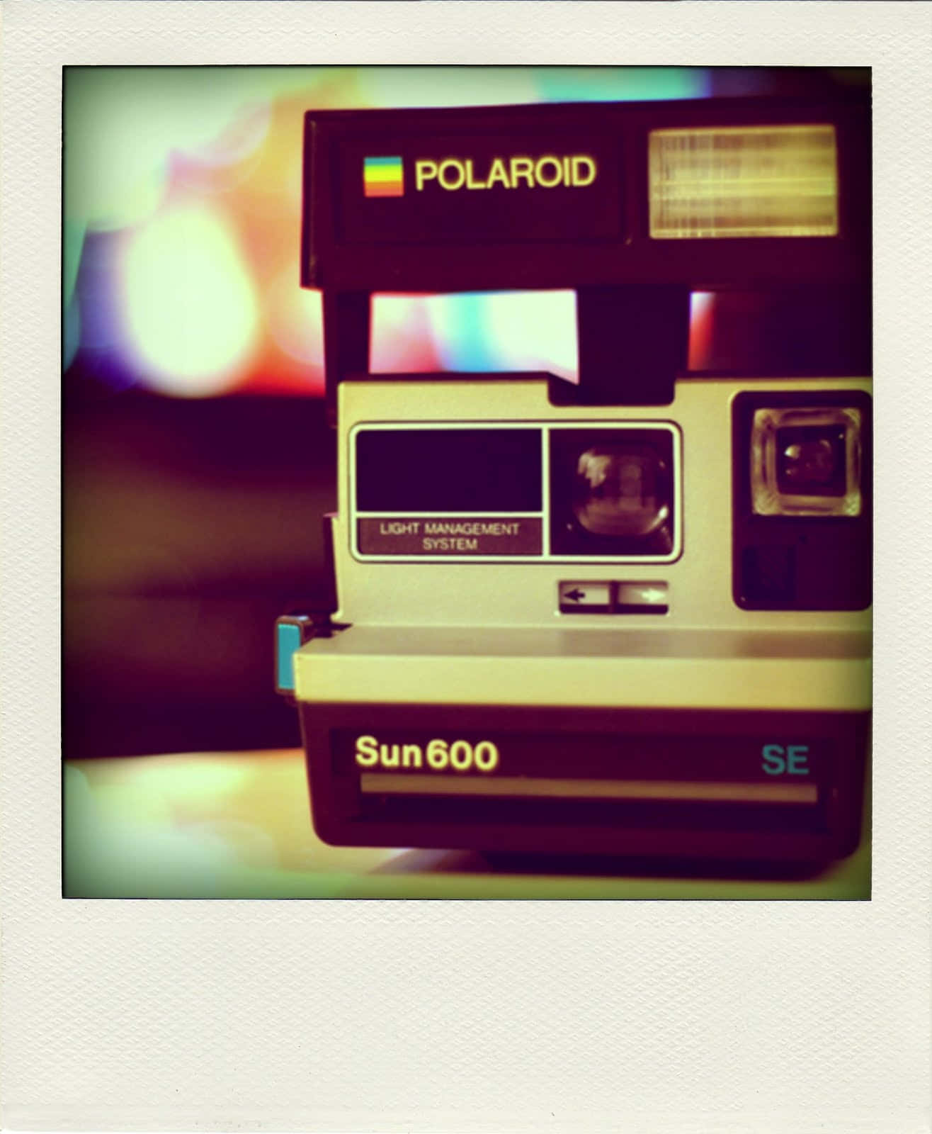 拍立得 桌布 壁紙 — 一部復古Polaroid Sun600 SE相機，帶有溫暖懷舊燈光和色彩繽紛的散景背景。