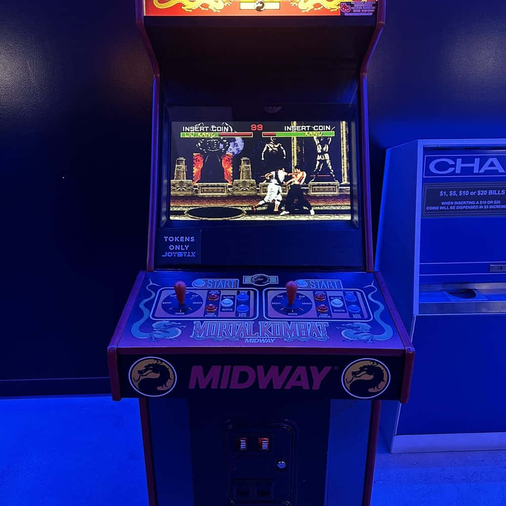 Arcade Games 桌布 壁紙 — 一部復古的Mortal Kombat街機在藍光下閃耀，格鬥遊戲正在進行中。