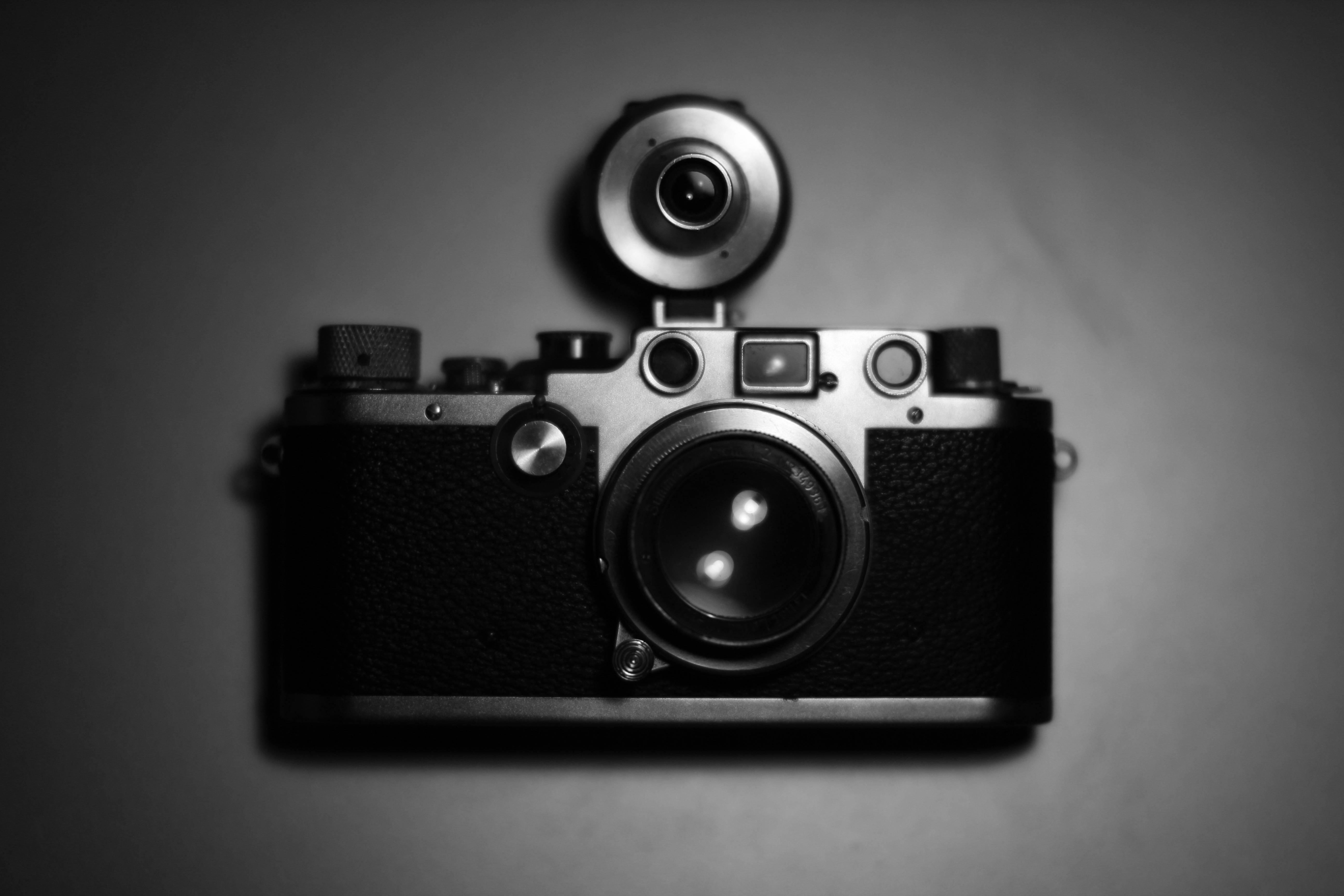 Webcam 桌布 壁紙 — 一部復古相機連閃光燈組件，居中放置在平滑的灰色背景上，呈現單色調。