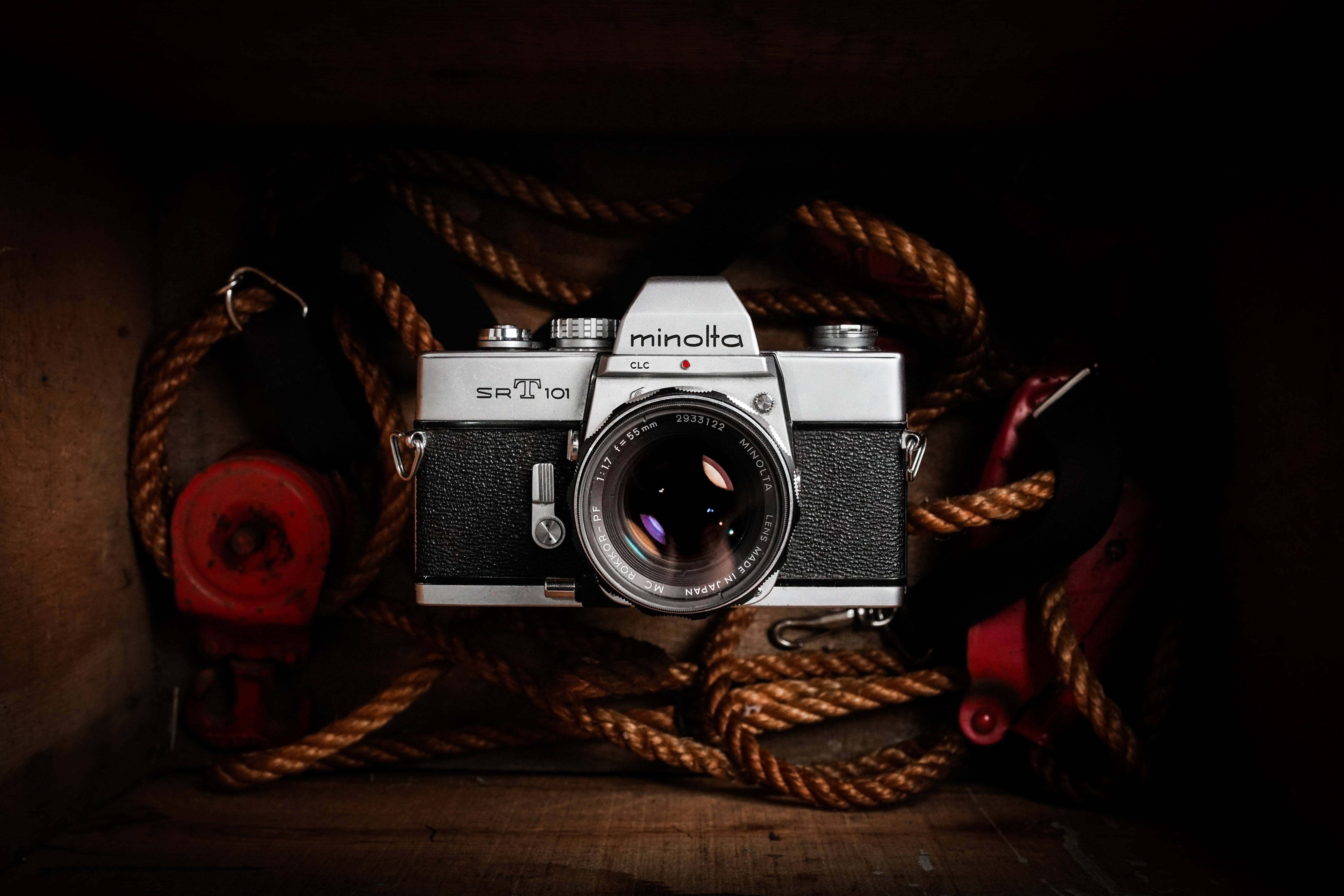 Retro Aesthetic 桌布 壁紙 — 一部復古銀色Minolta SR-T 101相機安放在一個昏暗的木箱中，周圍是粗大的棕色繩索和紅色航海裝備。