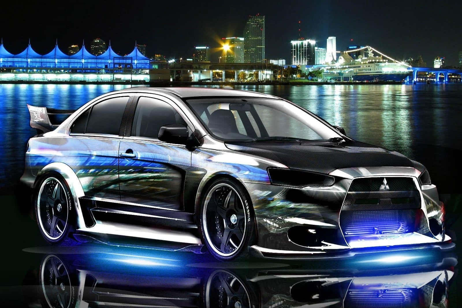 Tuned Car 桌布 壁紙 — 一部時尚改裝的三菱Lancer Evolution在夜間城市景觀倒映在水面上時，散發出藍色底盤燈光。
