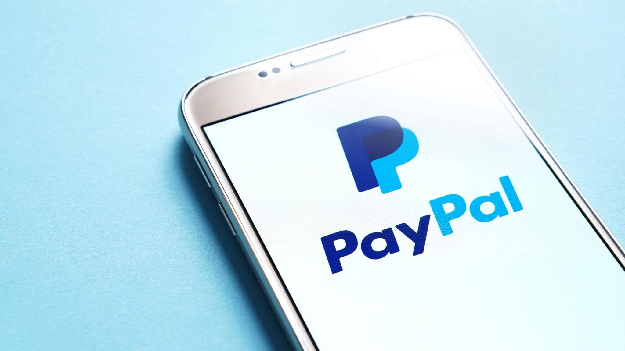 PayPal 桌布 壁紙 — 一部時尚智慧型手機在潔白螢幕上顯示PayPal標誌，背景為柔和藍色。