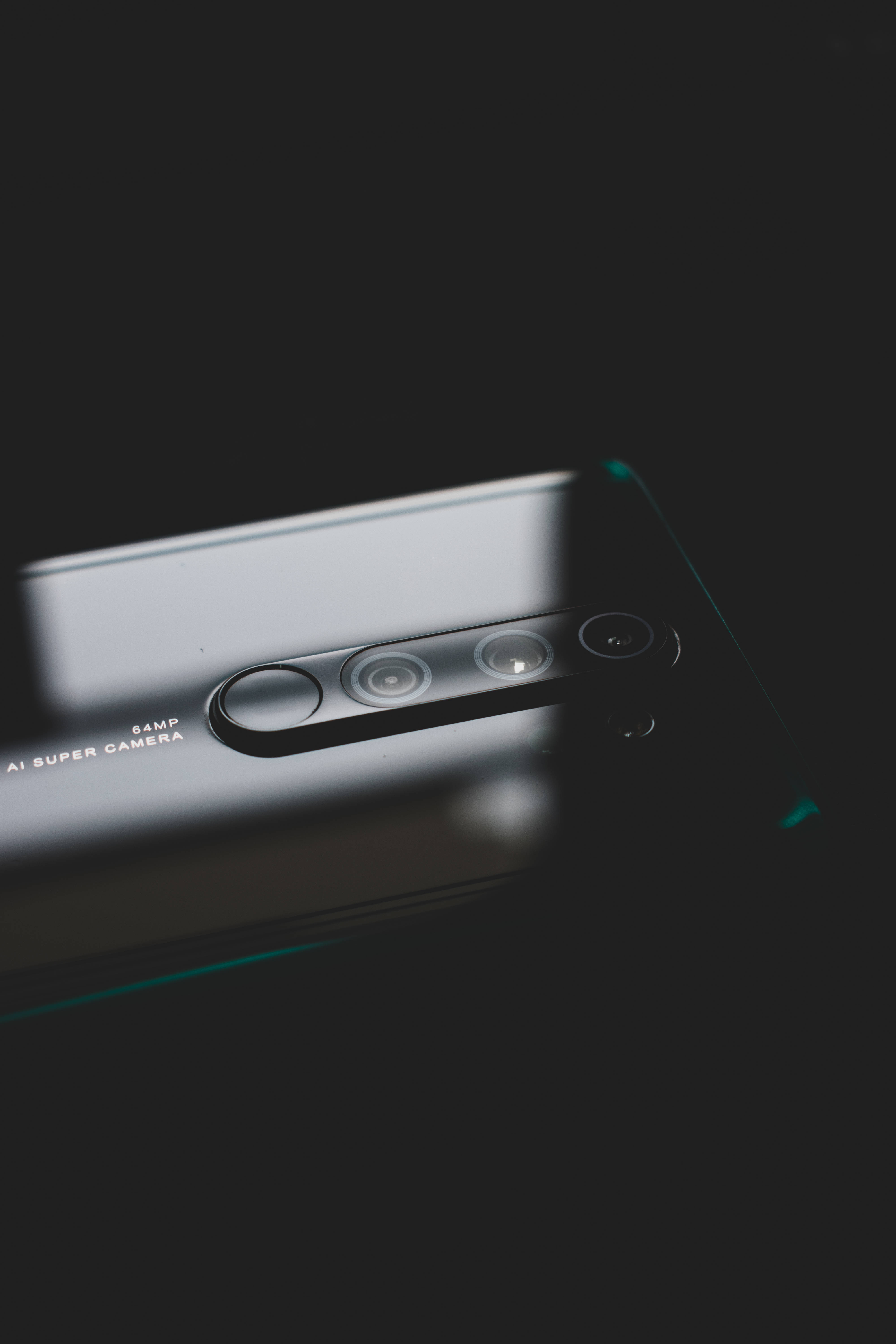 Webcam 桌布 壁紙 — 一部時尚智慧型手機配備四鏡頭陣列，在深色背景下微微發光。