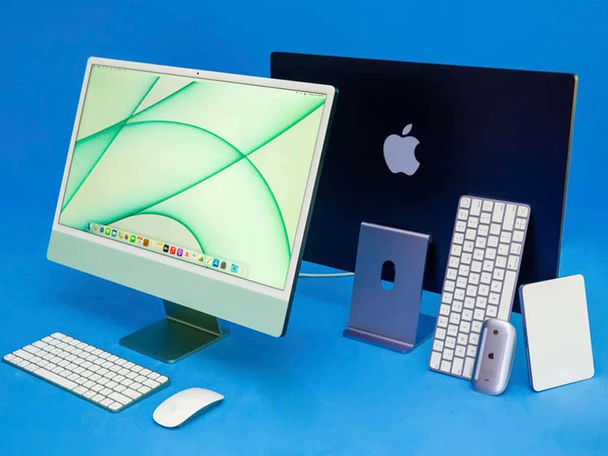 電腦 桌布 壁紙 — 一部時尚的 Apple iMac 配備白色鍵盤和滑鼠，放置在鮮藍色表面上，旁邊是其支架和配件。