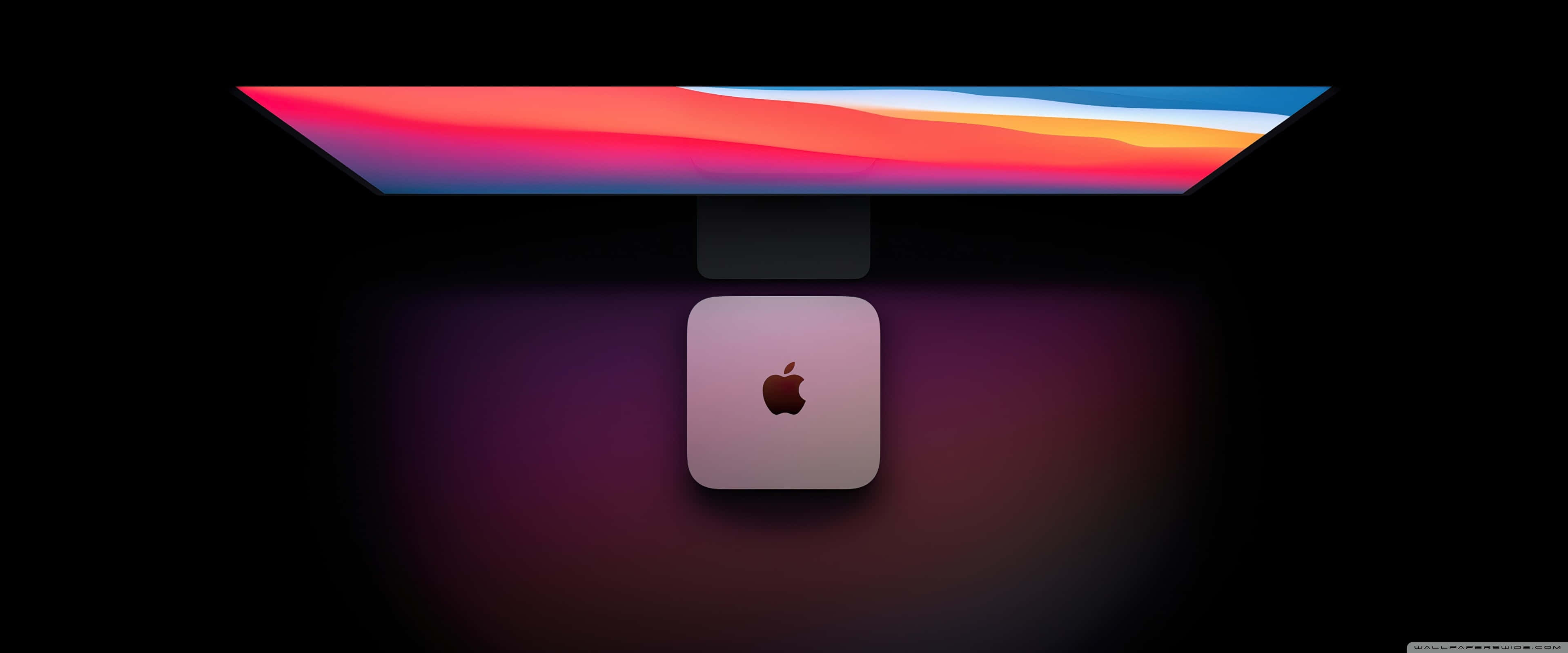Apple 3840x1600 桌布 壁紙 — 一部時尚的 Apple iMac，配備鮮豔的漸變顯示器和相配的 Mac Studio 底座，在黑暗背景下柔和發光。