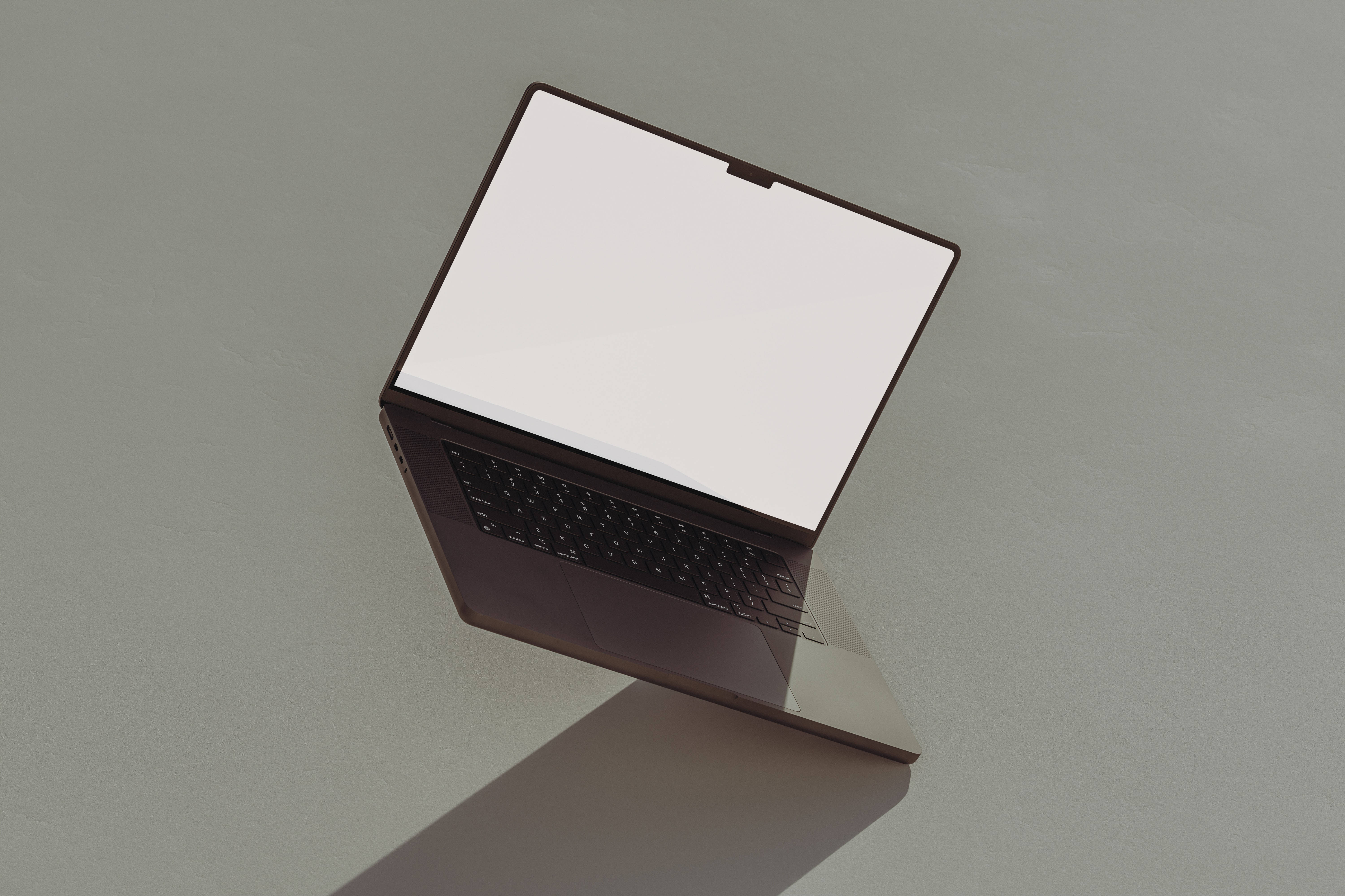 aesthetic tumblr laptop 桌布 壁紙 — 一部時尚的深色筆記型電腦，空白白色螢幕傾斜放置在極簡灰色表面上，投射出柔和陰影。