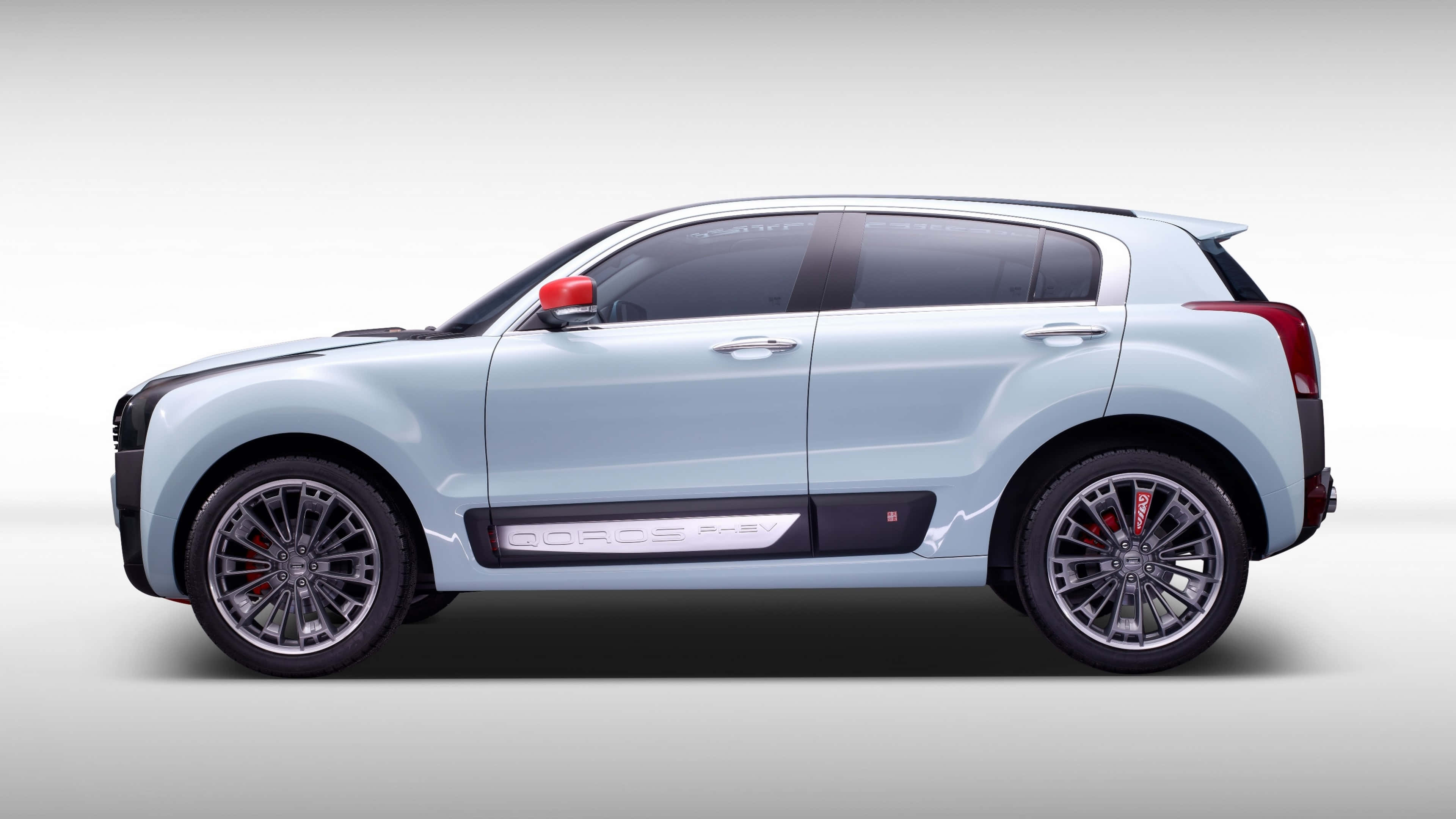 Qoros 桌布 壁紙 — 一部時尚的淺藍色 SUV，配備銀色輪圈和紅色制動卡鉗，在純白色背景上以側面展示。