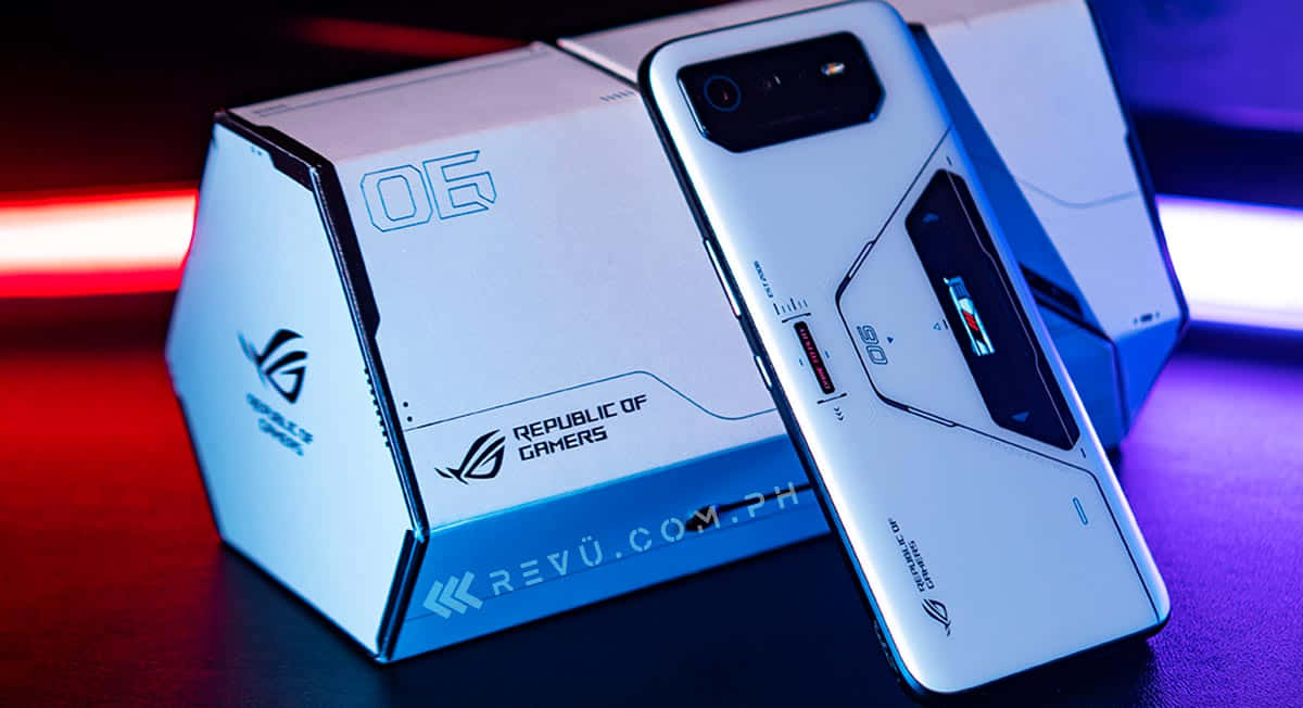 手機 桌布 壁紙 — 一部時尚的白色 ROG 遊戲手機靠在品牌盒子上，在鮮豔的紅色和藍色霓虹燈下。