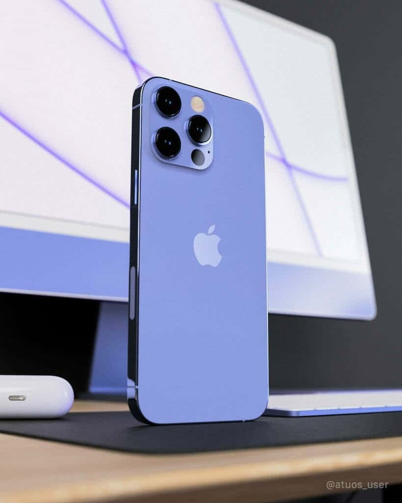 iPhone 桌布 壁紙 — 一部時尚的薰衣草色 iPhone 13 Pro 直立於桌上，旁邊有相配的顯示器和白色 AirPods 保護殼。