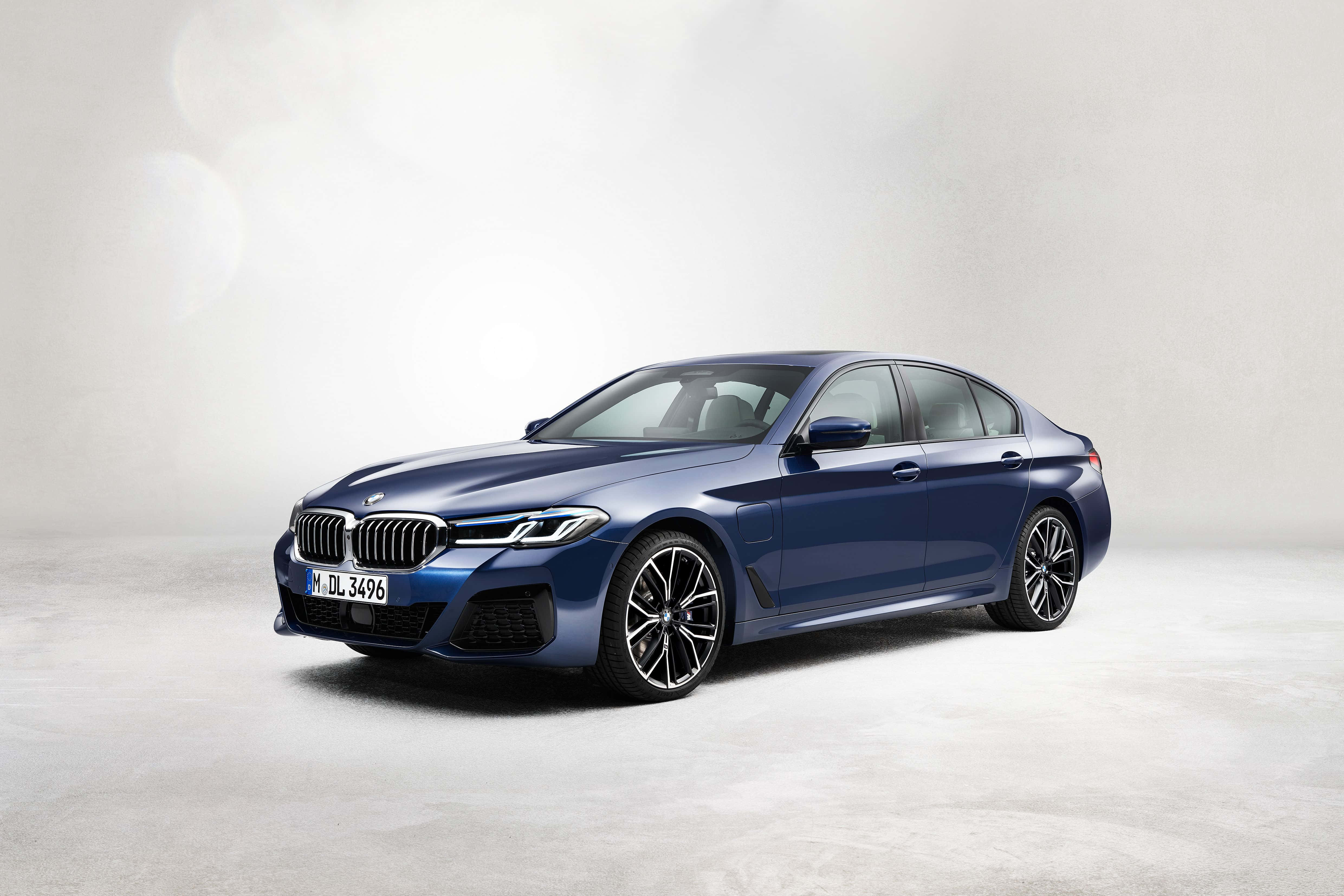Bmw M Sport 桌布 壁紙 — 一部時尚的藍色寶馬5系列轎車在柔和的工作室燈光下，在簡約的灰色背景前閃閃發光。