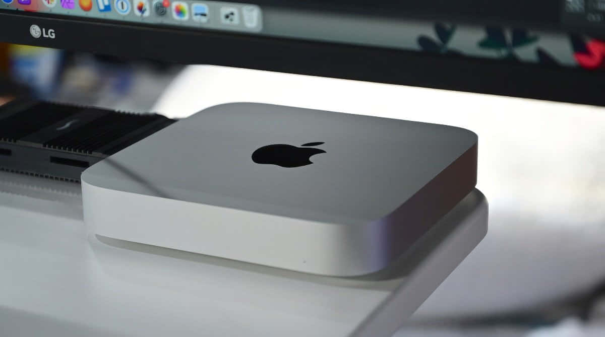 Mac 桌布 壁紙 — 一部時尚的銀色 Apple Mac mini 放在白色桌子上，背景有 LG 顯示器。