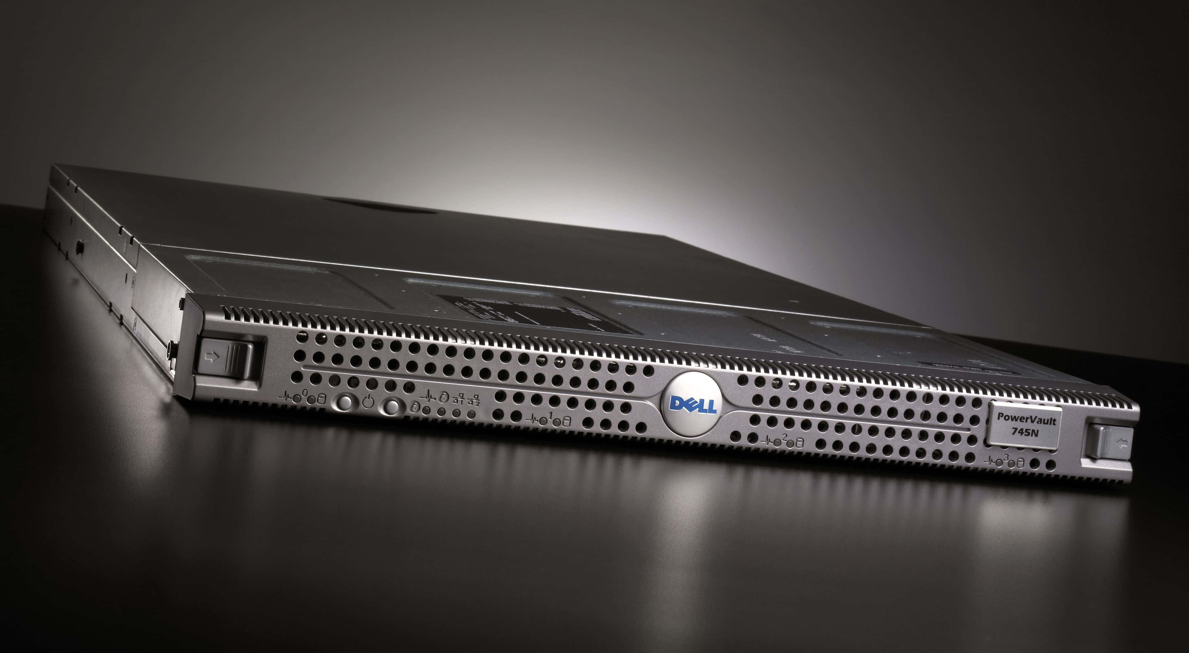Dell 桌布 壁紙 — 一部時尚的銀色 Dell PowerVault 745N 伺服器放置在反光的黑色表面上，在戲劇性的工作室燈光下。