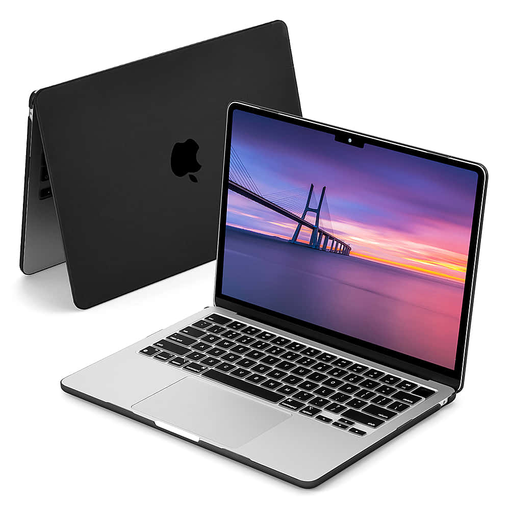 Black Macbook 桌布 壁紙 — 一部時尚的銀色筆記型電腦，配備黑色鍵盤，顯示現代吊橋上充滿活力的日落，旁邊是其關閉的霧面黑色保護套。