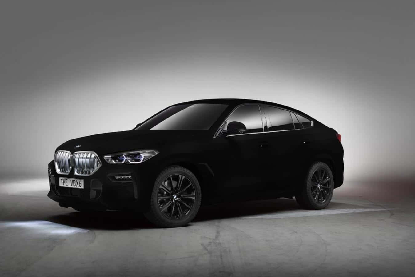 Vantablack 桌布 壁紙 — 一部時尚的黑色BMW X6 SUV在極簡主義的工作室中展示，混凝土地板上帶有戲劇性的聚光燈。