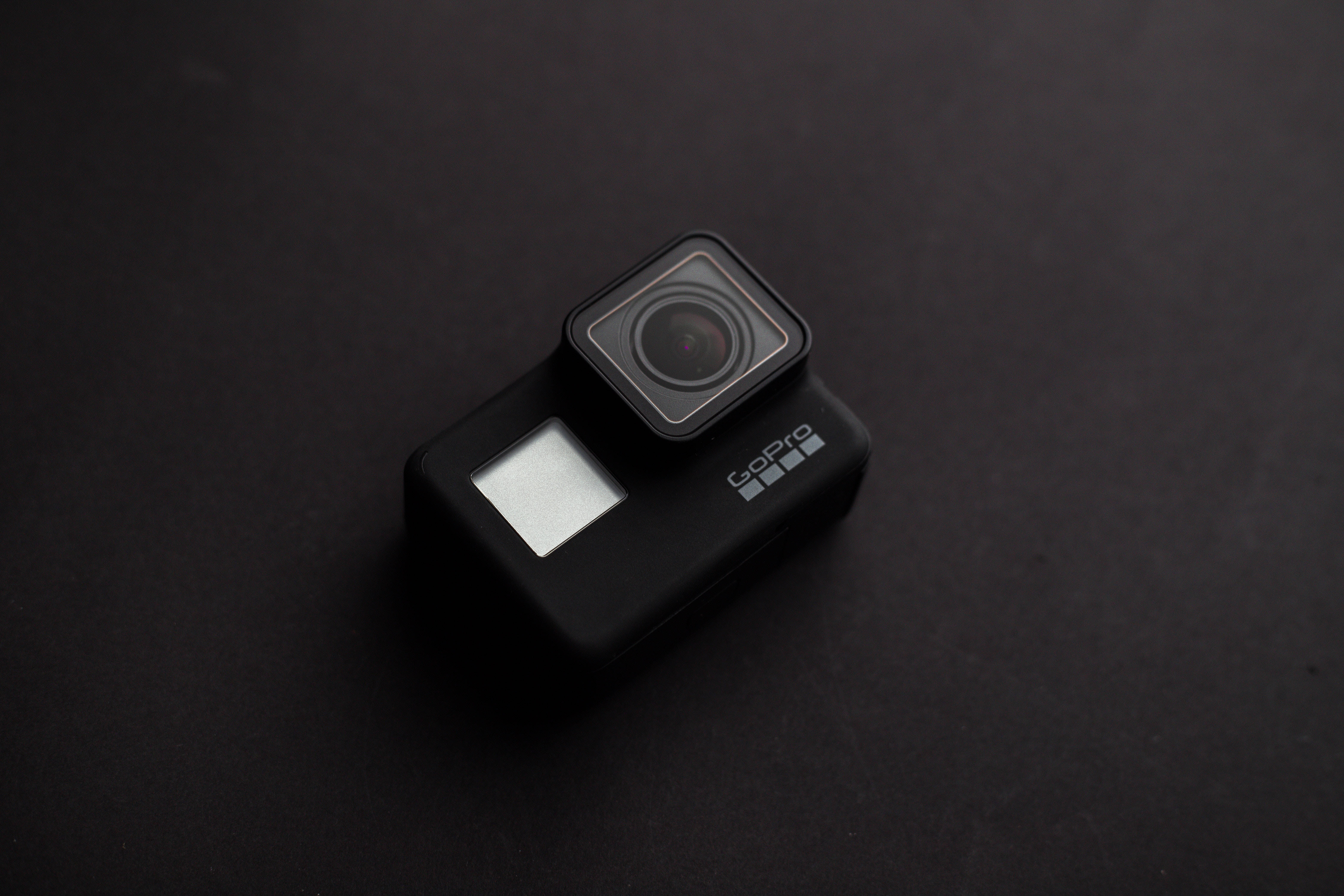 攝影 桌布 壁紙 — 一部時尚的黑色GoPro相機在柔和的工作室燈光下放置在磨砂深色表面上。