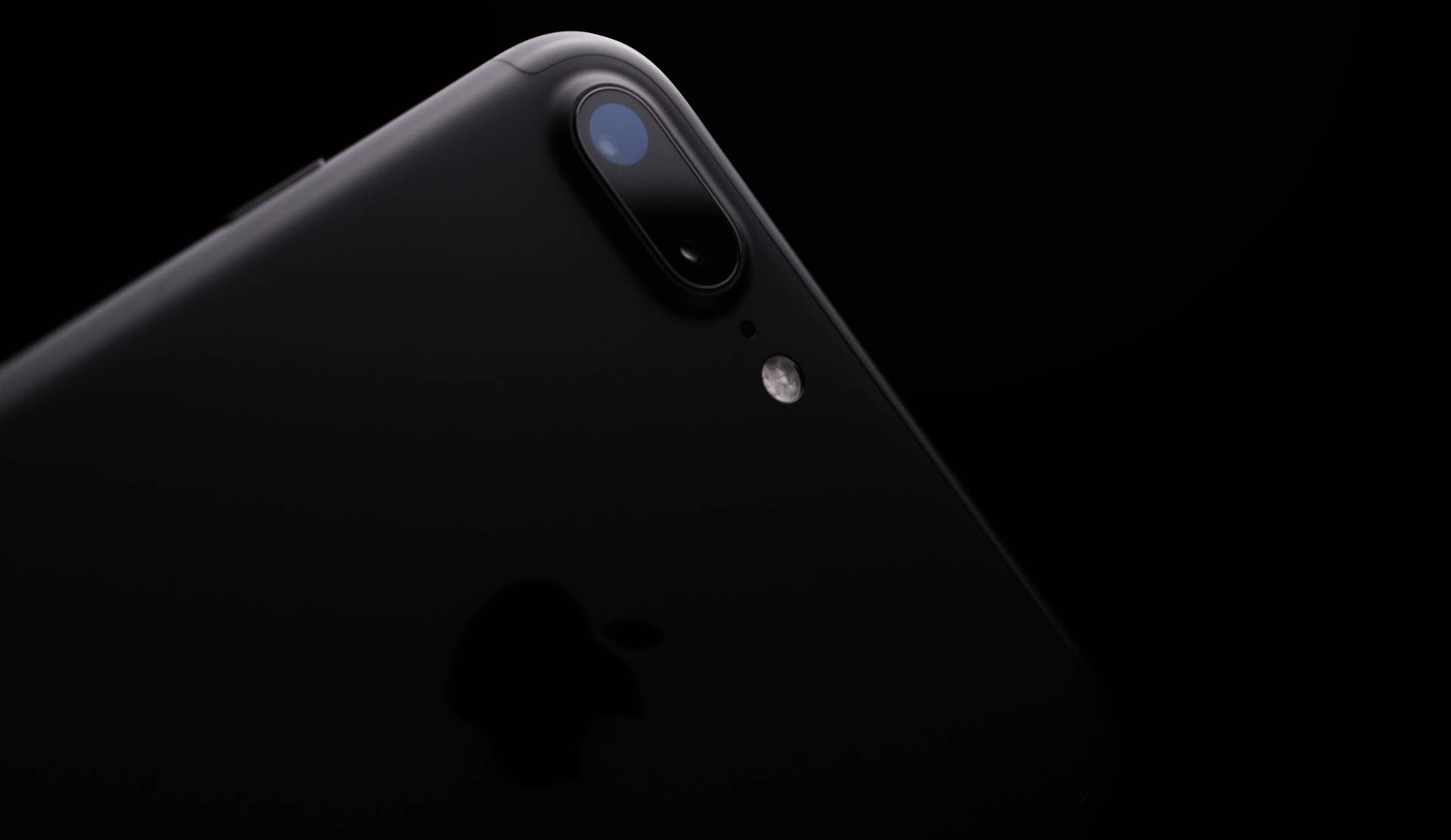 黑色iPhone的特寫，在深色背景上顯示相機和標誌。 — iPhone 14 壁紙