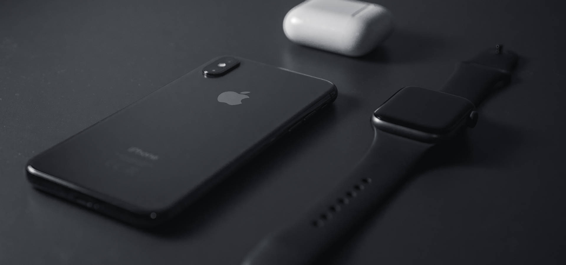 黑色iPhone Apple Watch和白色AirPods保護殼在深色表面上 — 智慧手錶 GIF 壁紙