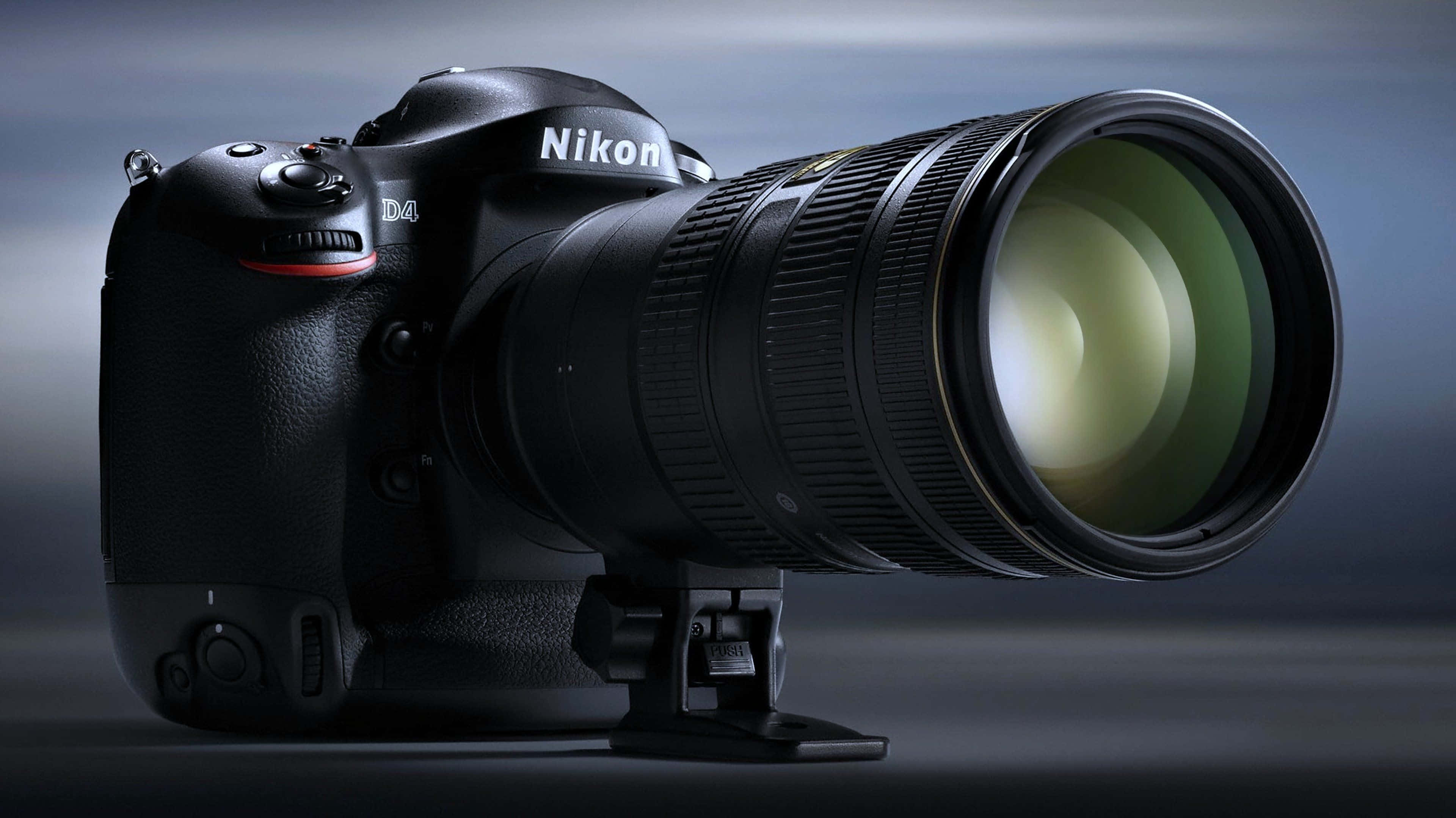 攝影 桌布 壁紙 — 一部時尚的黑色Nikon D4 DSLR相機配備大型望遠鏡頭，在富有氣氛的漸層背景前蓄勢待發。