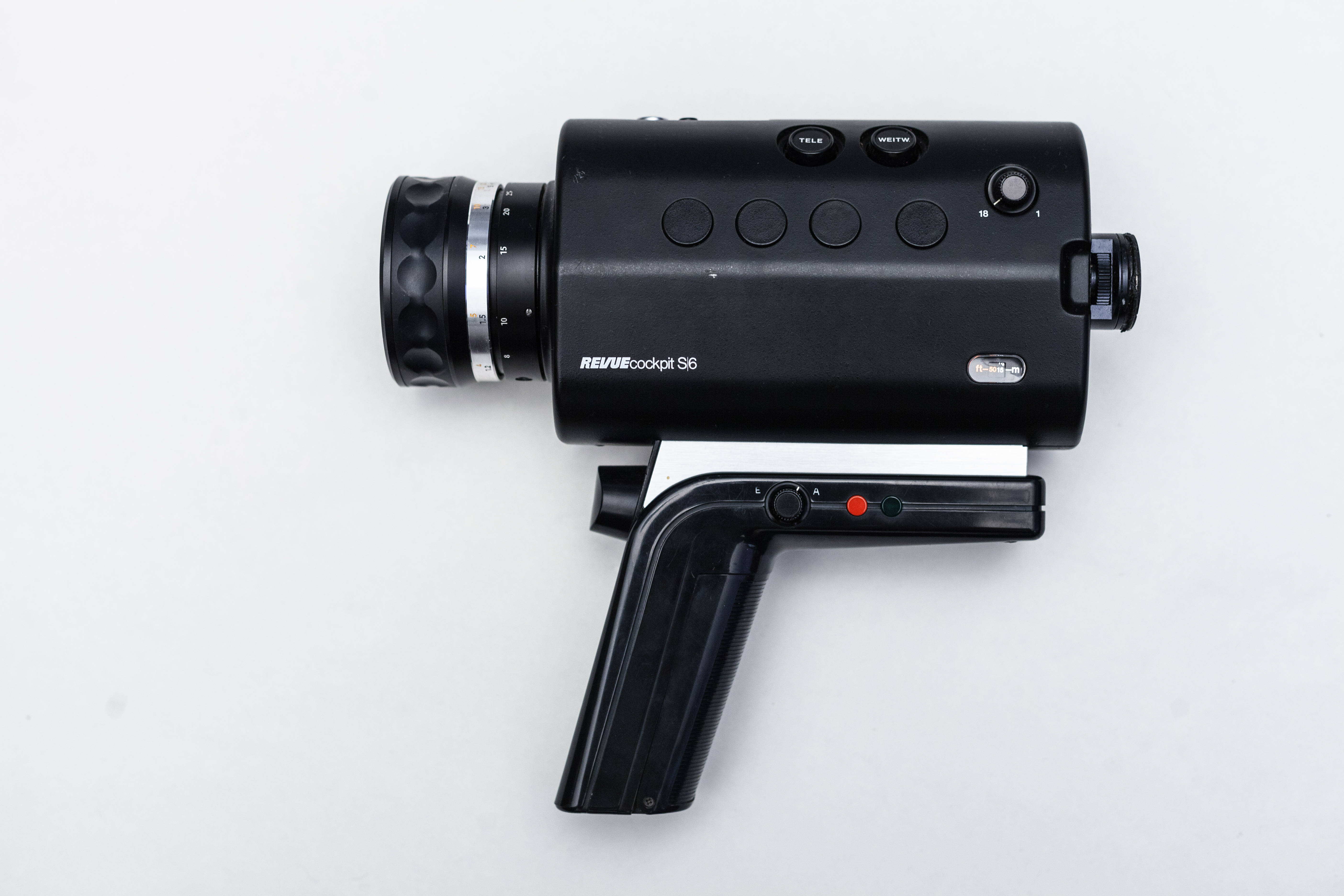 Webcam 桌布 壁紙 — 一部時尚的黑色Revue cockpit S6手持攝影機放置在純白色表面上，展示其符合人體工學的握把和控制按鈕。