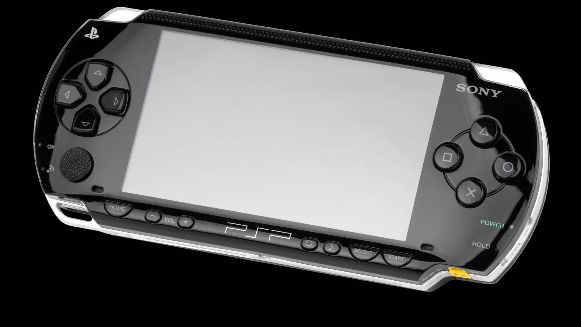 遊戲 桌布 壁紙 — 一部時尚的黑色和銀色 Sony PSP 手提遊戲機，配備空白螢幕和發光的電源按鈕，背景為深色。