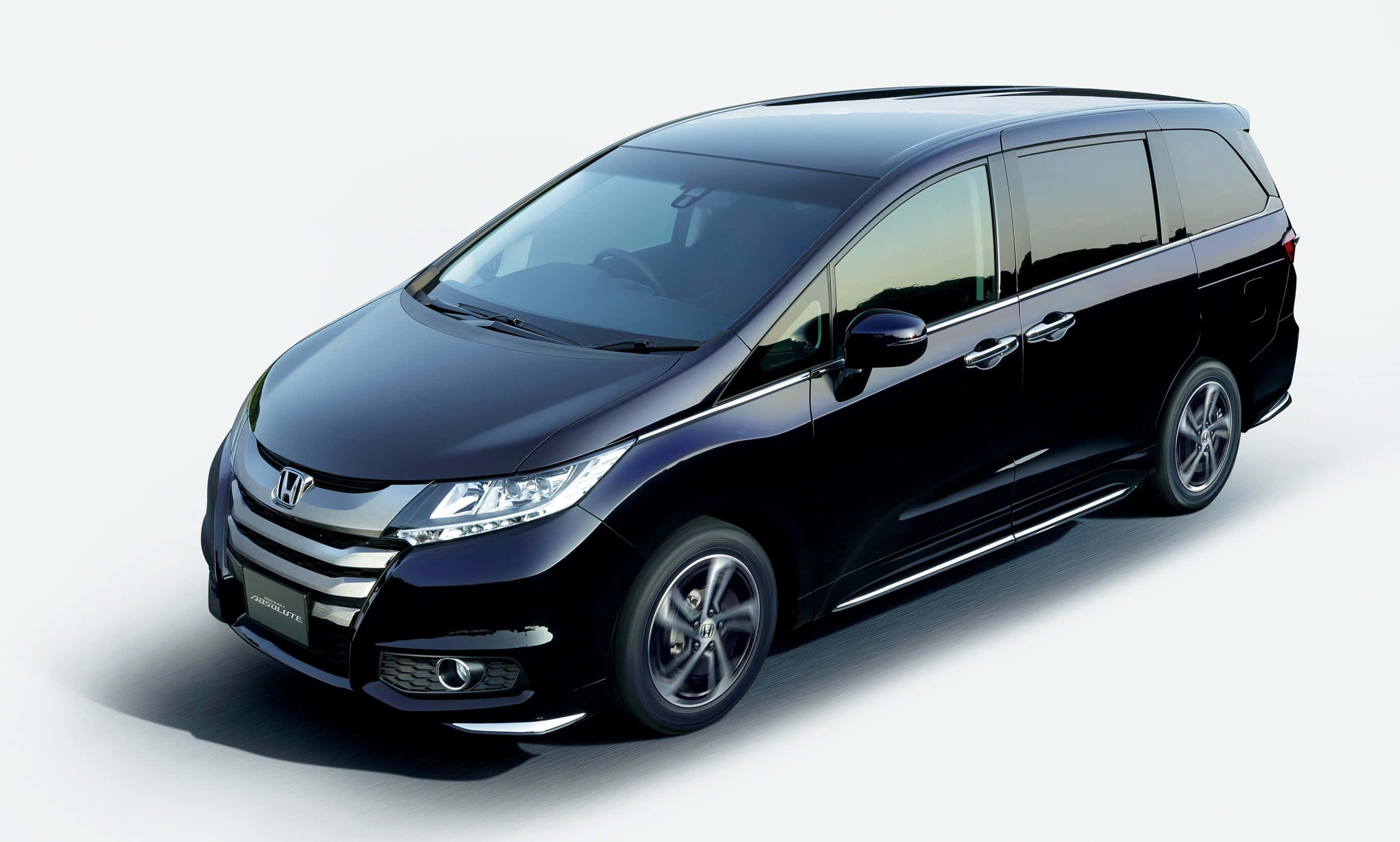 Honda Odyssey 桌布 壁紙 — 一部時尚的黑色本田Odyssey小型客車在乾淨的攝影棚環境中展示，光線柔和，陰影細膩。