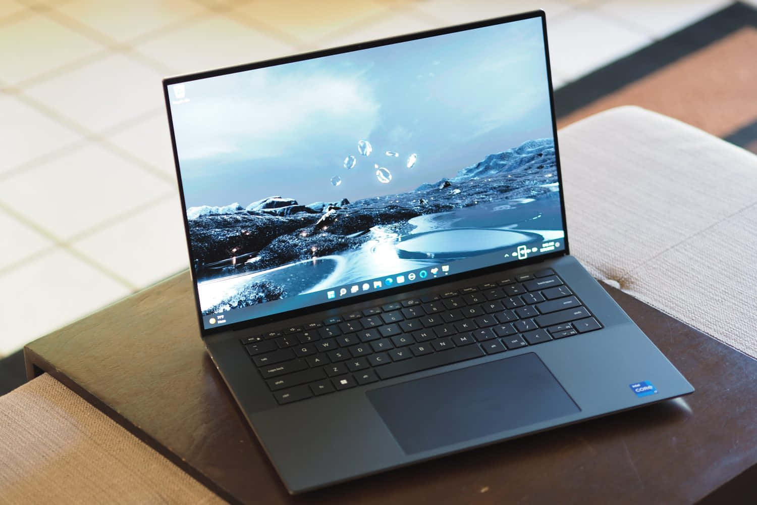Dell 桌布 壁紙 — 一部時尚筆記型電腦在木桌上顯示雪山的風景和漂浮的氣泡。