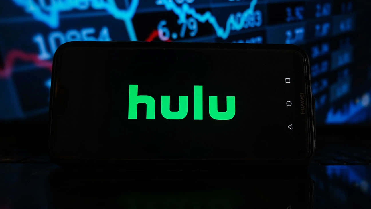 Hulu 桌布 壁紙 — 一部智慧型手機在深色背景上顯示綠色Hulu標誌及發光藍色金融圖表。