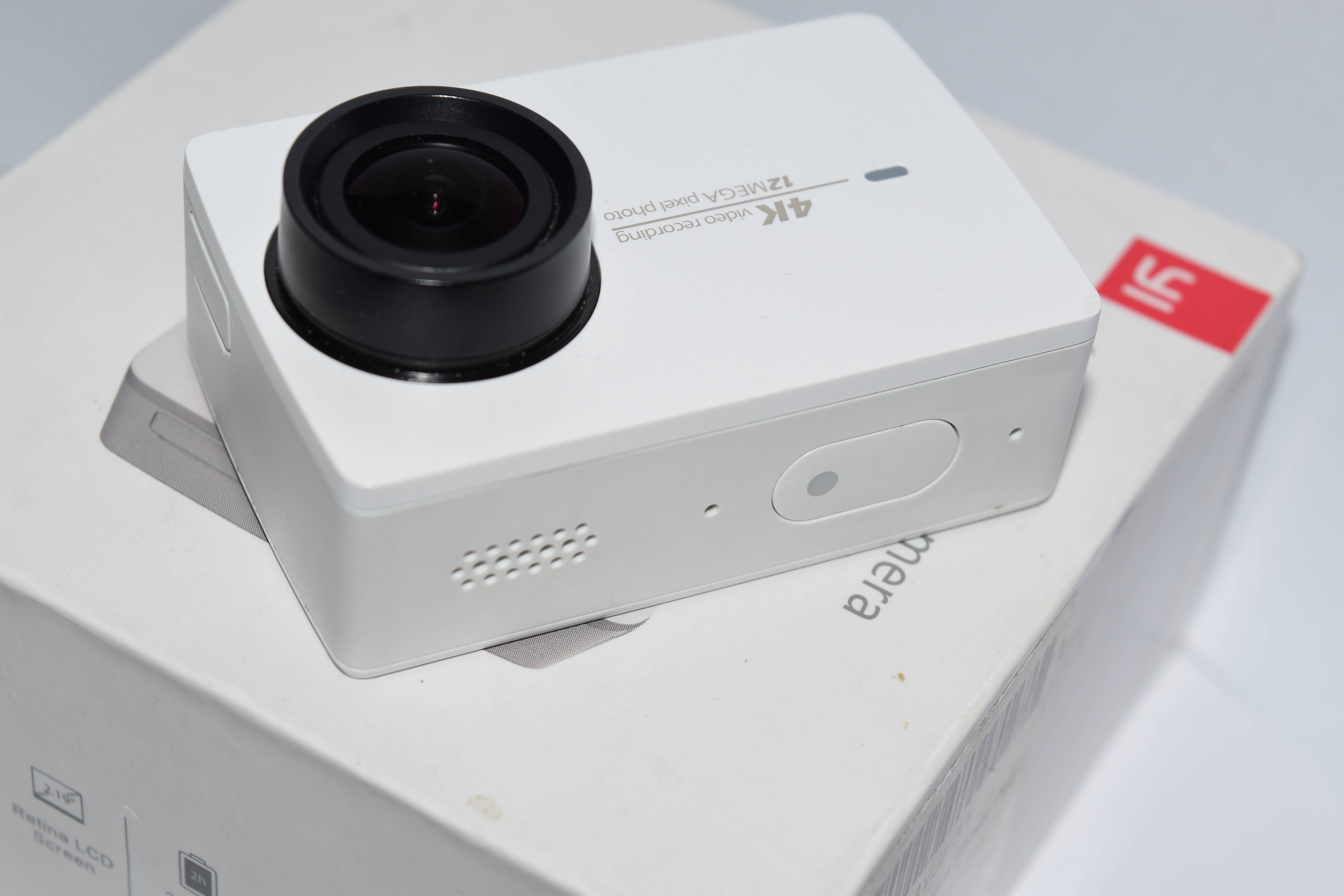 Xiaomi 桌布 壁紙 — 一部白色運動相機配黑色鏡頭，放在其匹配的盒子上，處於簡潔極簡的環境中。