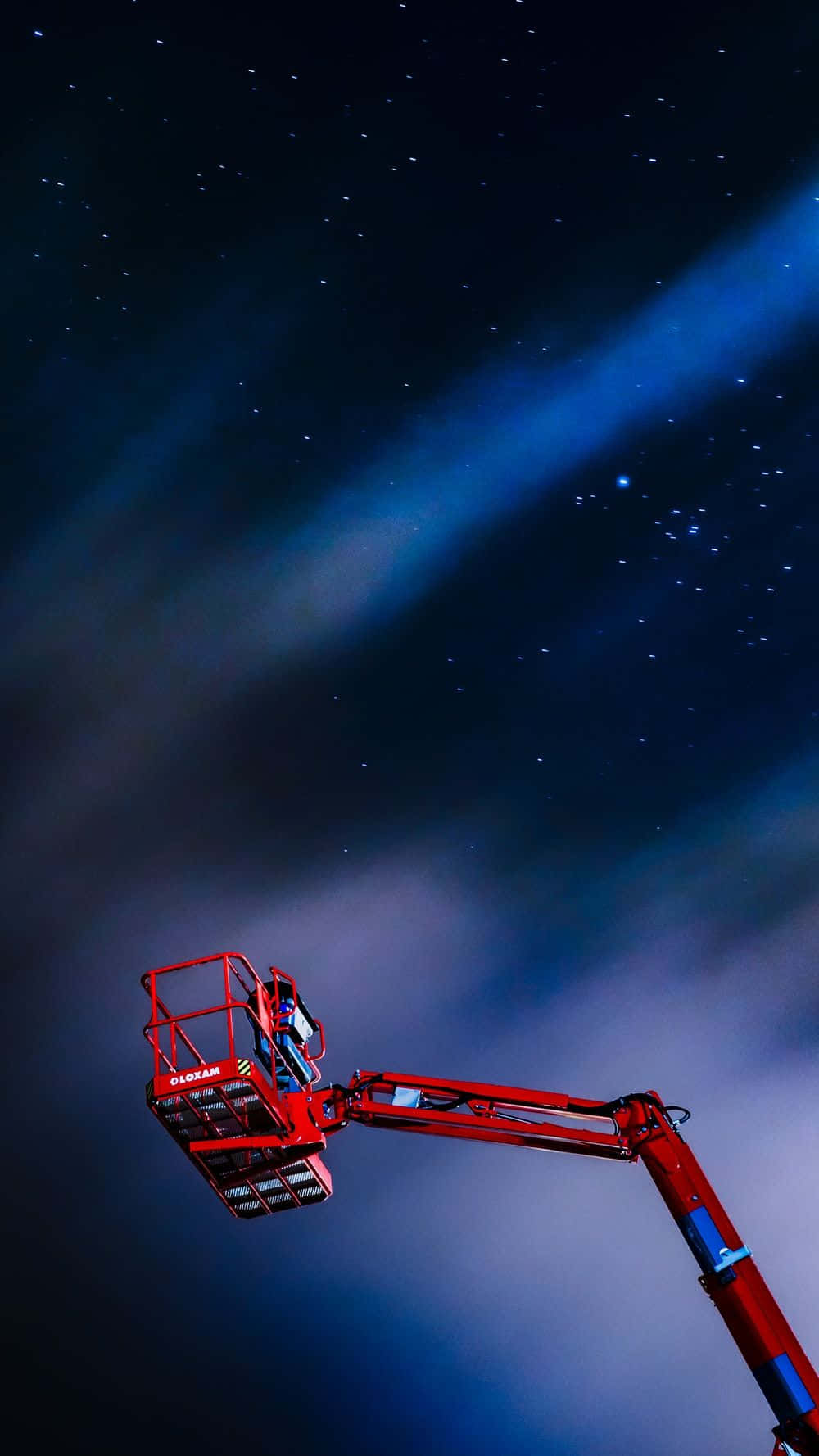 Stars 桌布 壁紙 — 一部紅色櫻桃採摘機吊臂伸入點綴著鮮豔藍色極光的星空夜空。