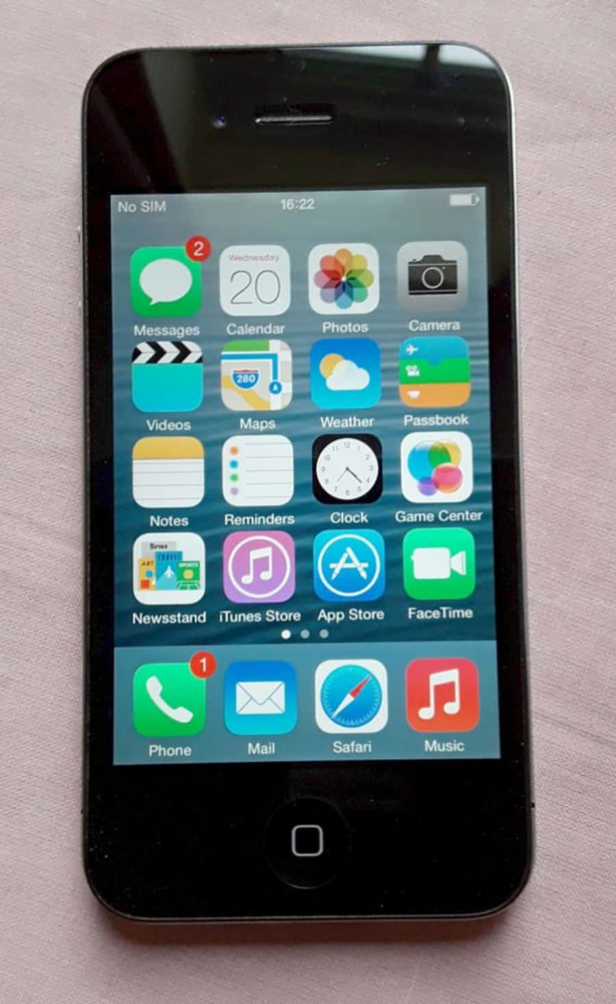 手機 桌布 壁紙 — 一部黑色 iPhone 4S 在藍色漸層背景上顯示其 iOS 主畫面，帶有色彩繽紛的應用程式圖示。