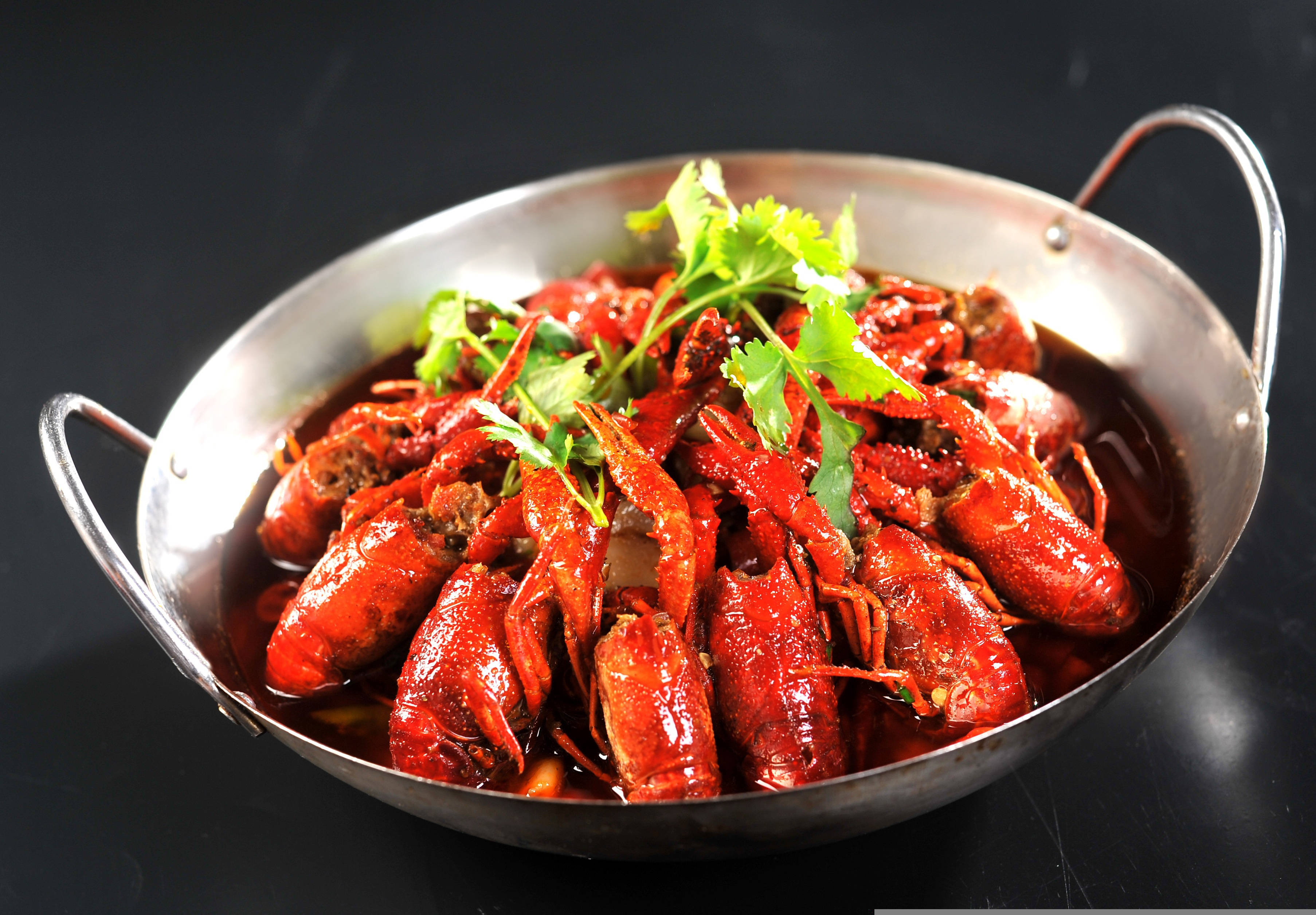 Lobster 桌布 壁紙 — 一鍋冒泡的鮮紅色辣小龍蝦，配上新鮮香菜，放在閃亮的金屬鍋中，背景為深色。