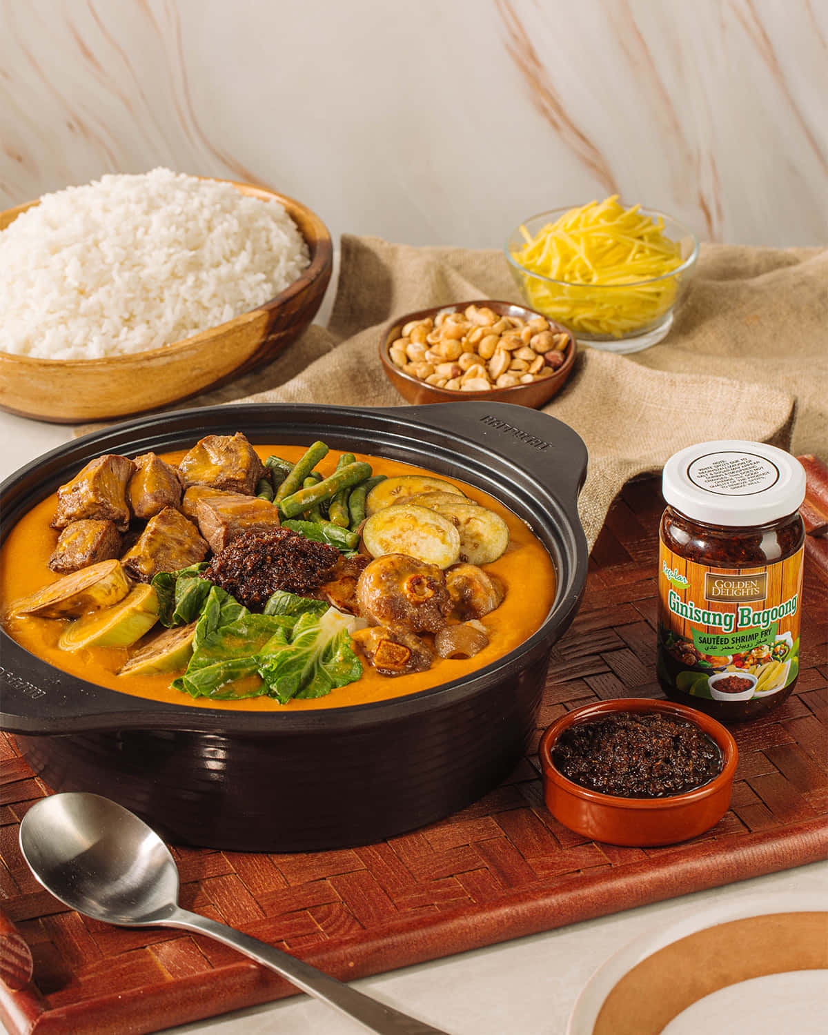 Vegetables 桌布 壁紙 — 一鍋冒著熱氣的濃郁橙棕色 ginisang bagoong 燉菜，配有雞肉、蔬菜和青菜，搭配米飯、花生和碎起司。