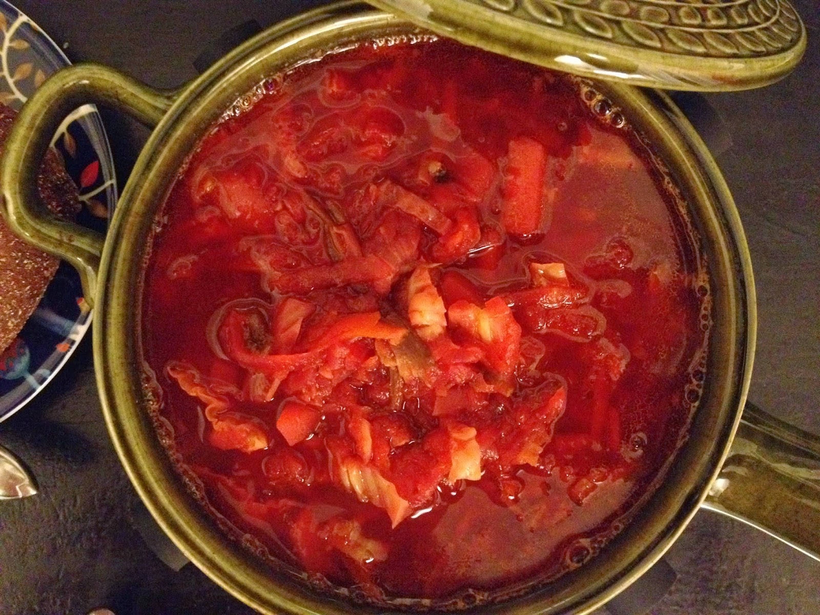 beetroot 桌布 壁紙 — 一鍋冒著蒸氣的濃郁紅色番茄湯，可見番茄和洋蔥塊，在綠色蓋子下慢煮。
