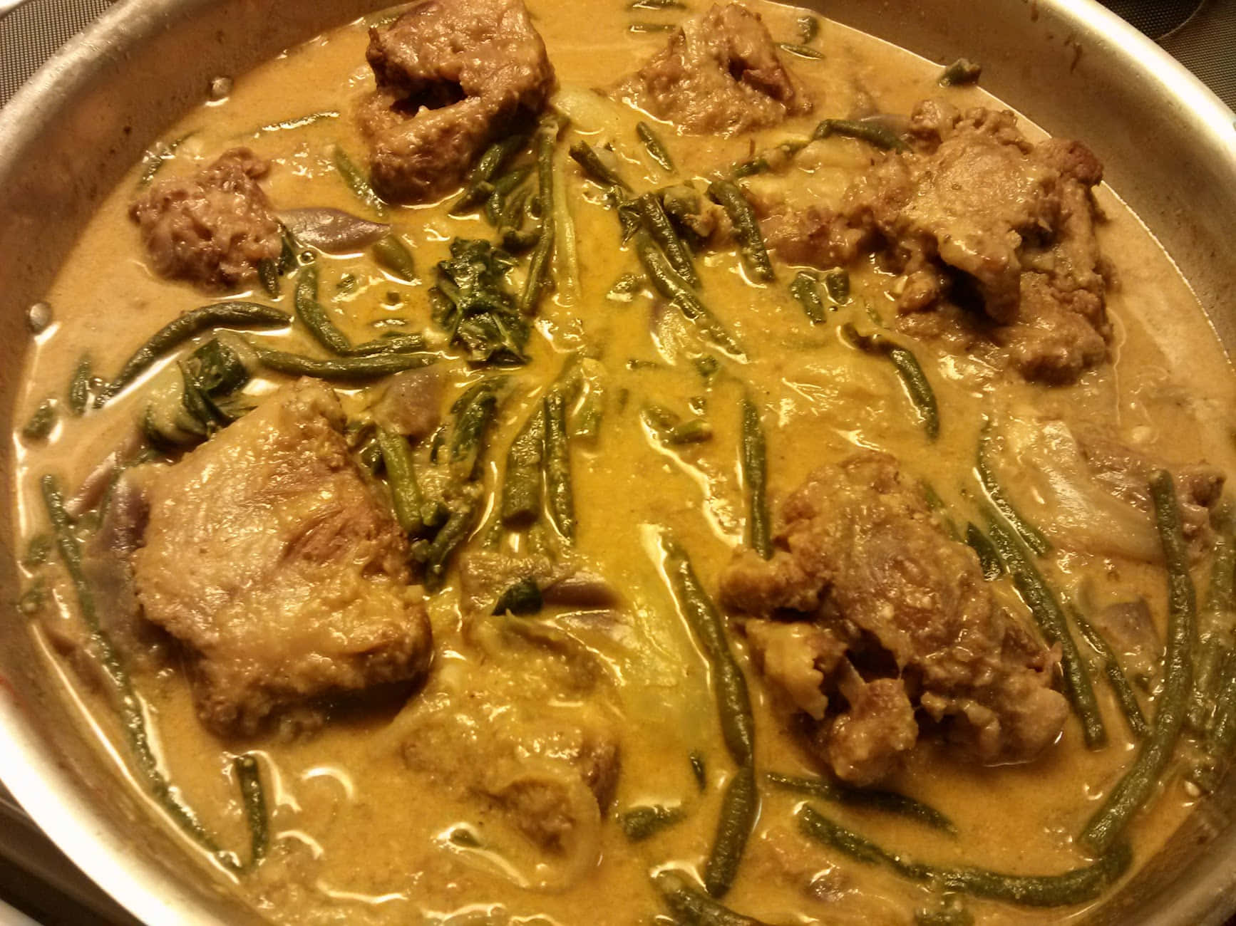 meat 桌布 壁紙 — 一鍋冒著蒸氣的濃郁黃咖哩，裡面有嫩肉塊和青豆在光澤的醬汁中燉煮。