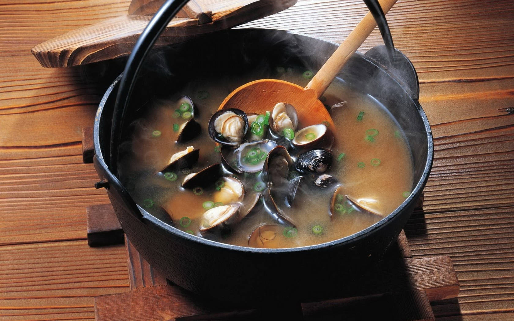 Food Photography 桌布 壁紙 — 一鍋蜆湯，湯裡有蔥，放在木面上，鍋蓋半開，冒著蒸氣。