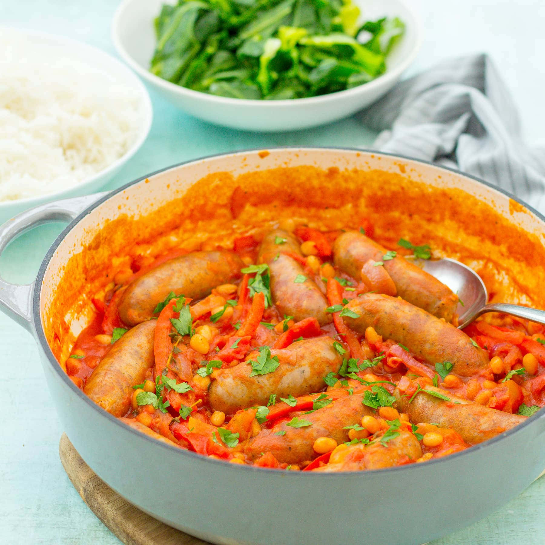 Sausage 桌布 壁紙 — 一鍋豐盛的香腸，用濃郁的番茄醬汁搭配豆子和甜椒慢燉，並以新鮮香草點綴。