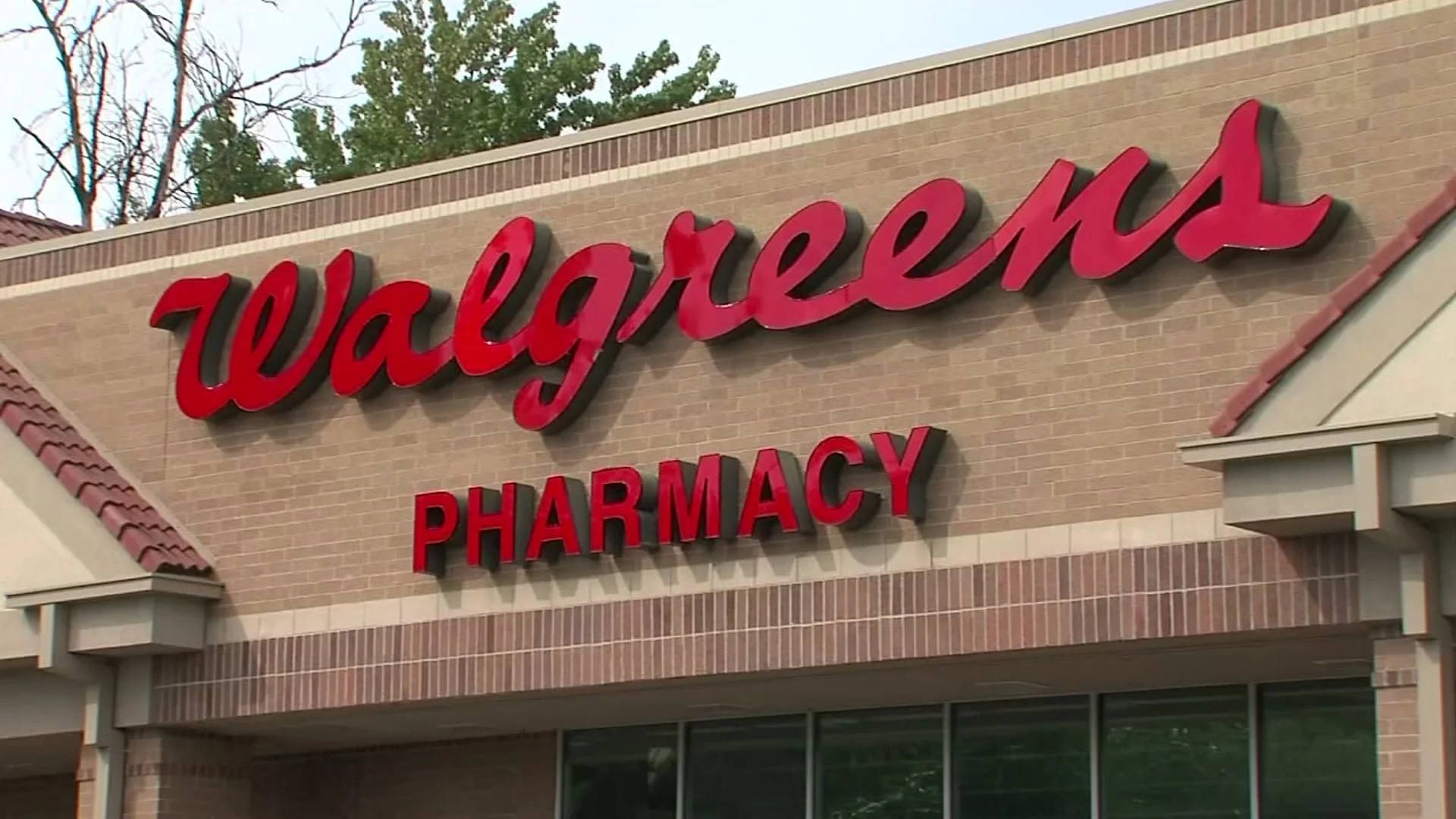 標誌 桌布 壁紙 — 一間 Walgreens 藥房店面，在晴朗天空下，米色磚砌建築上裝有醒目的紅色招牌。