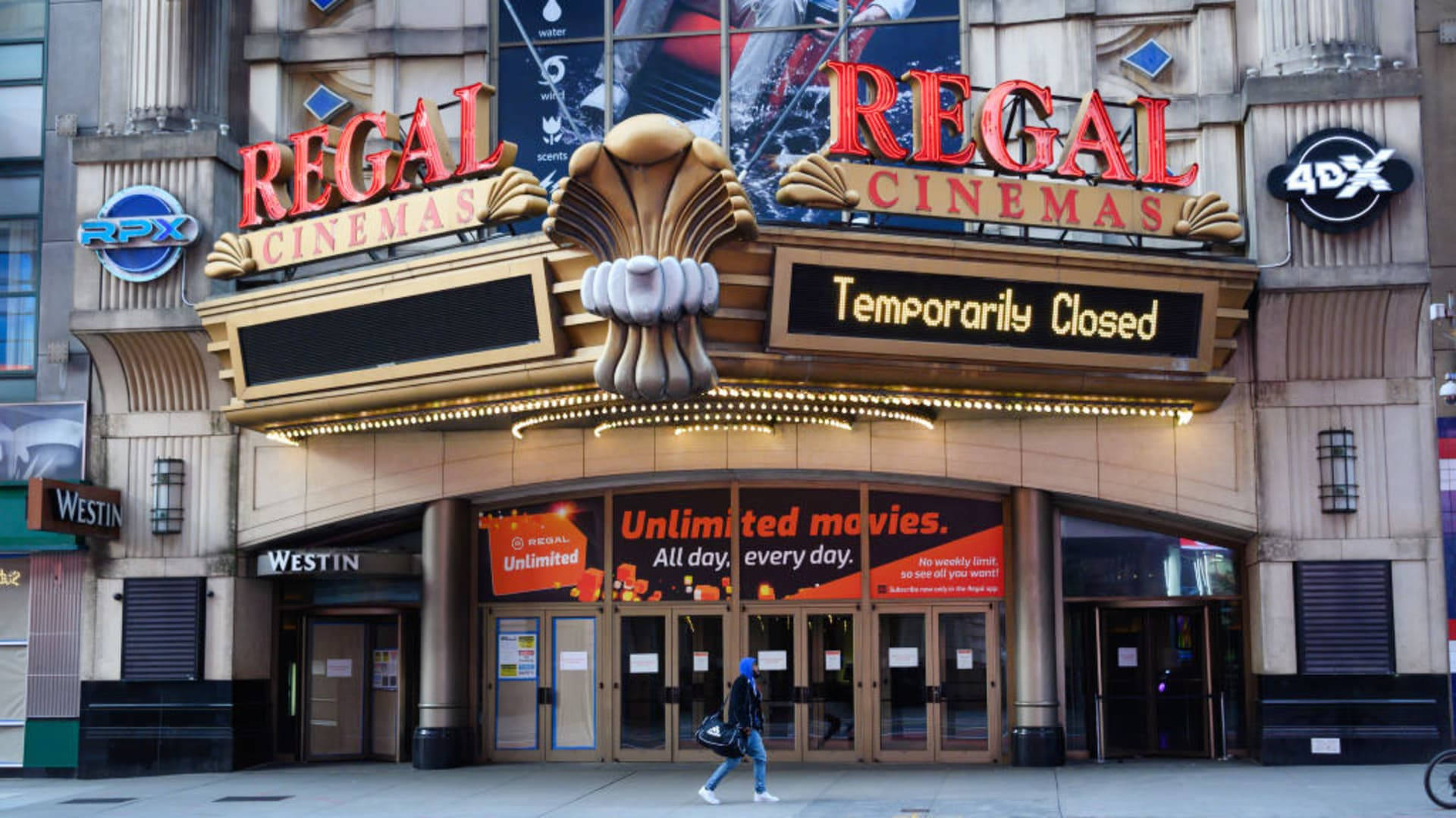 Regal 桌布 壁紙 — 一間Regal Cinemas戲院，帶有「暫時關閉」的標誌，一個孤獨的行人經過其宏偉入口。