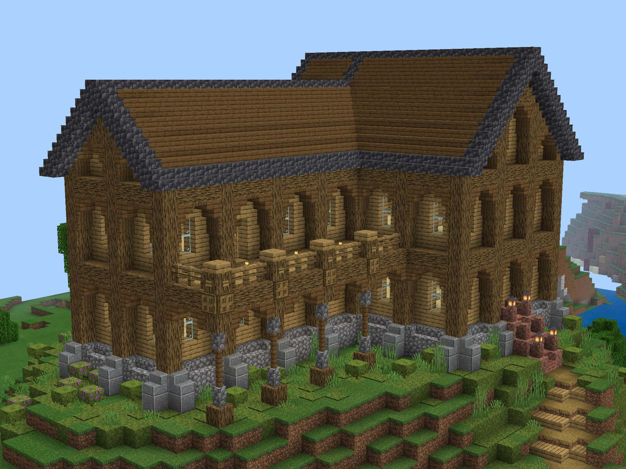 Minecraft Server 桌布 壁紙 — 一間像素化木屋，帶有石頭地基和發光窗戶，坐落於Minecraft景觀中的草坡上。
