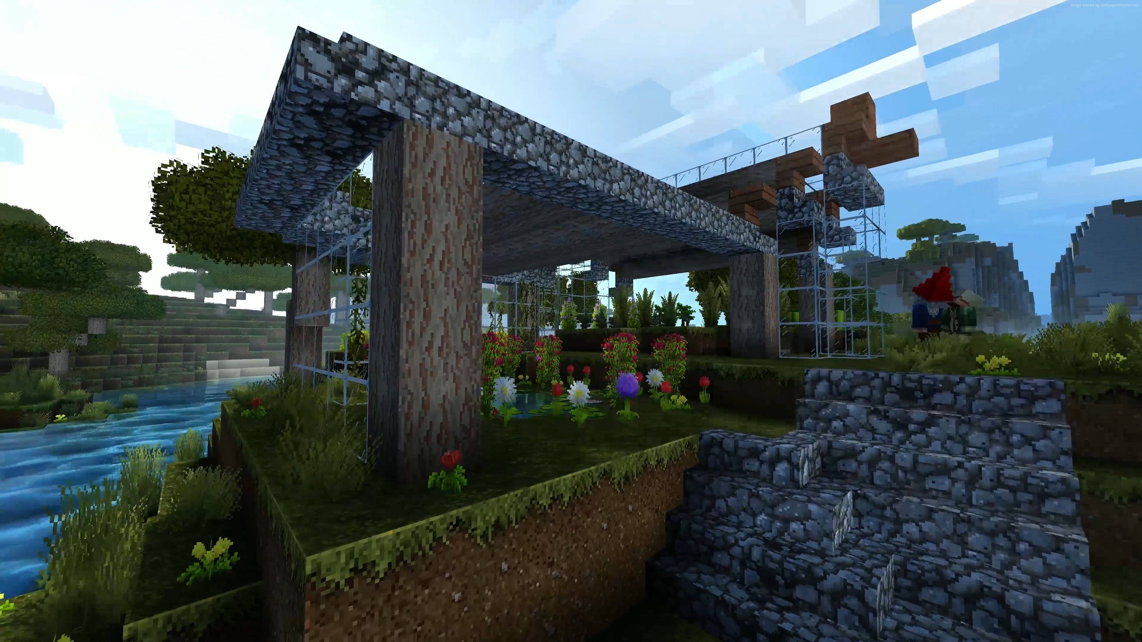 4K Minecraft 壁紙 桌布 壁紙 — 一間像素化的Minecraft房屋，擁有石頭屋頂和木柱，坐落在河邊，周圍環繞著色彩繽紛的花朵和樹木，在明亮的天空下。