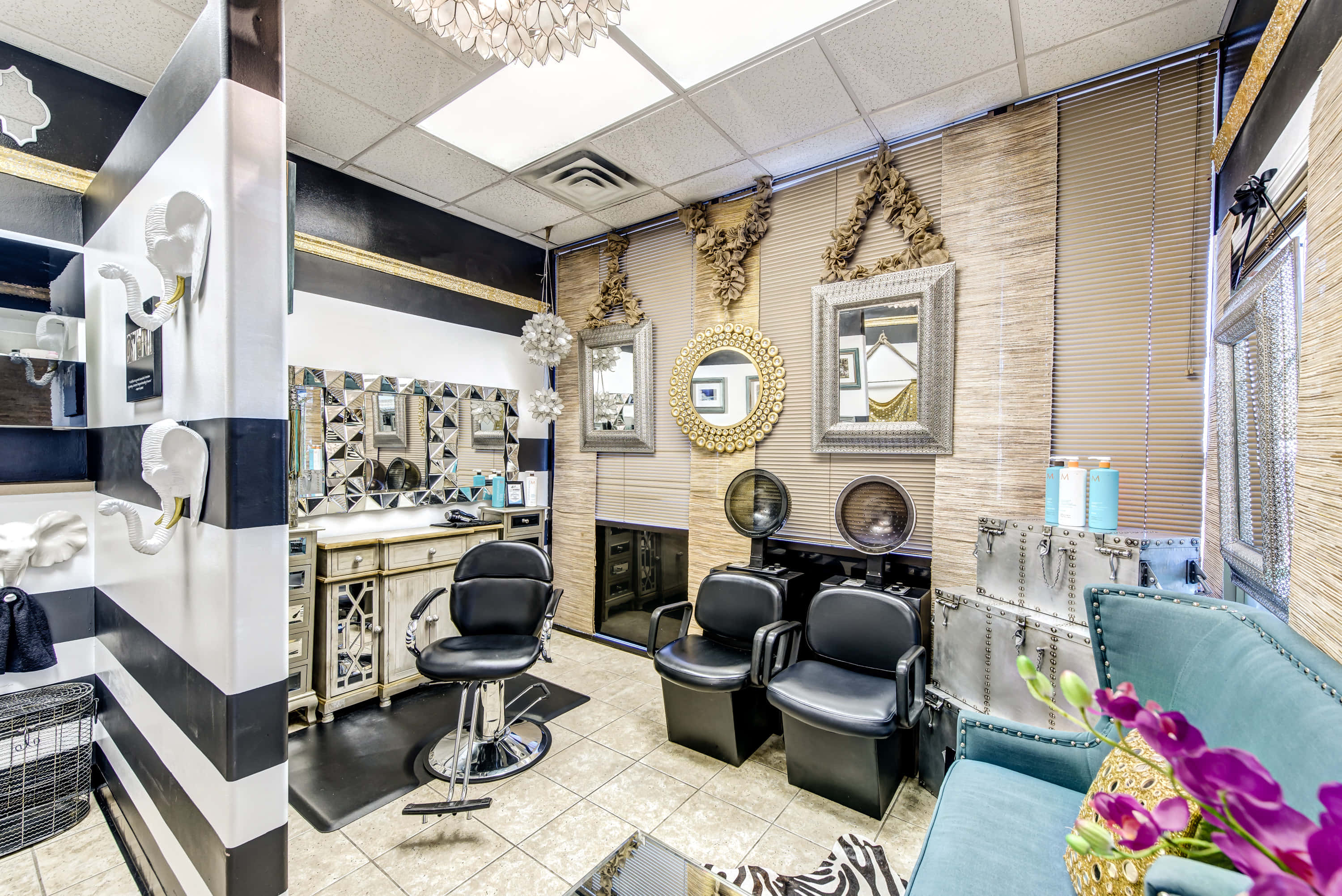 Hair Salon 桌布 壁紙 — 一間別緻的黑白理髮店，配有華麗的鏡子、造型椅和充滿活力的紫色花朵，增添了一抹色彩。