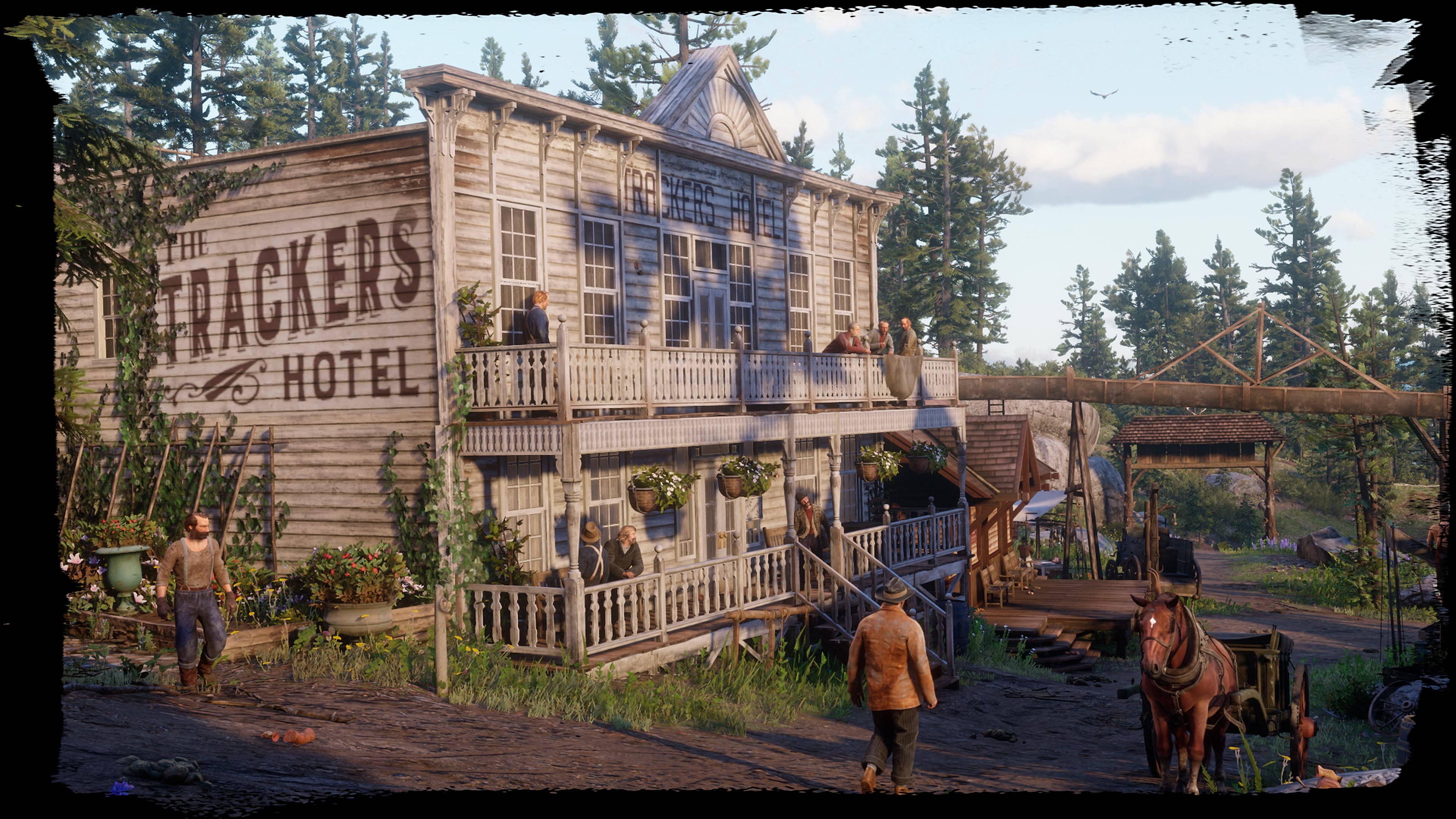 電玩遊戲 桌布 壁紙 — 一間名為「The Trackers Hotel」的風化木造兩層酒店，矗立在質樸的西部小鎮，附近有人們和馬車。