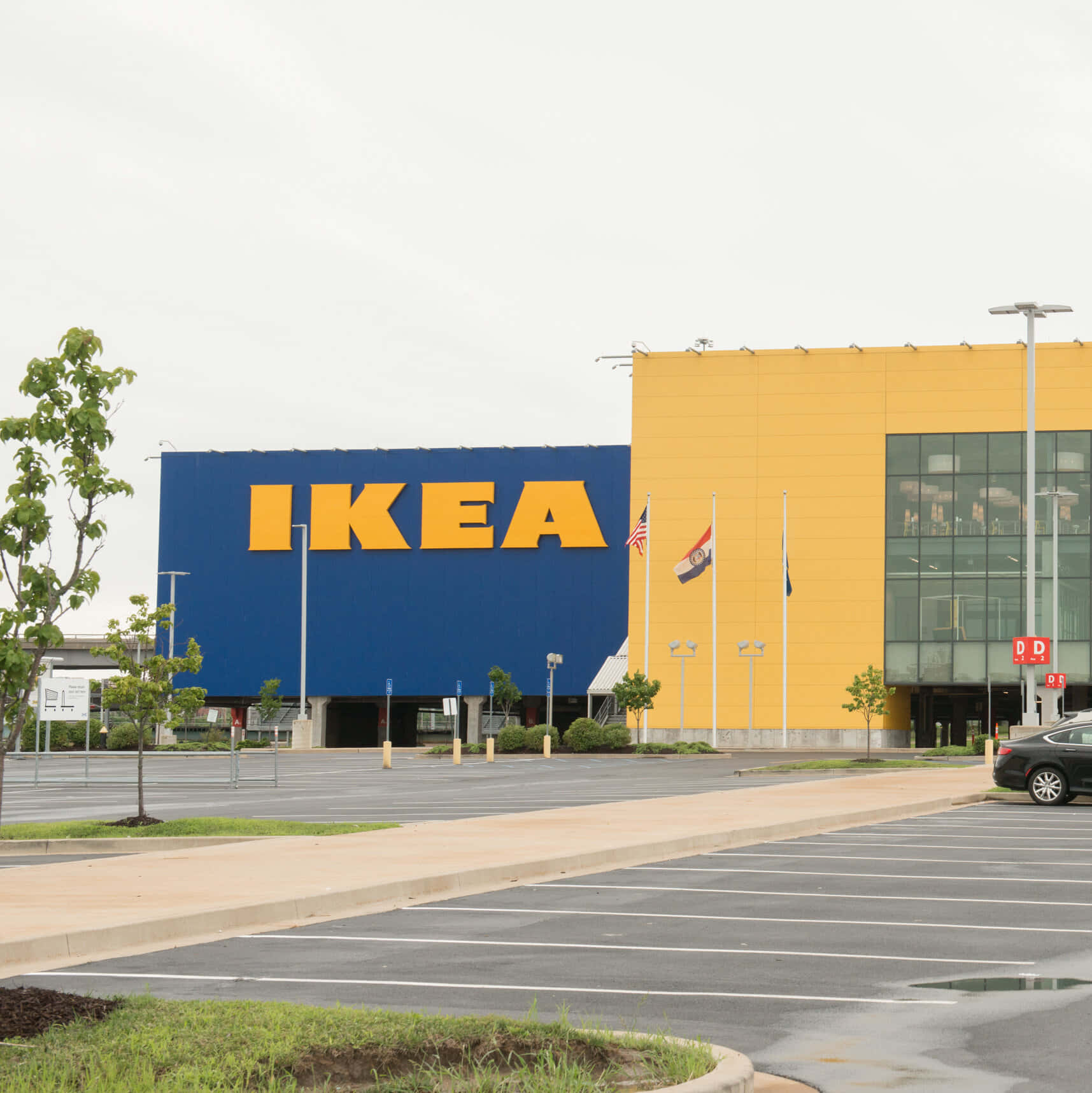 Ikea 桌布 壁紙 — 一間大型IKEA商店，藍色和黃色的外牆，天空多雲，停車場幾乎空無一車。